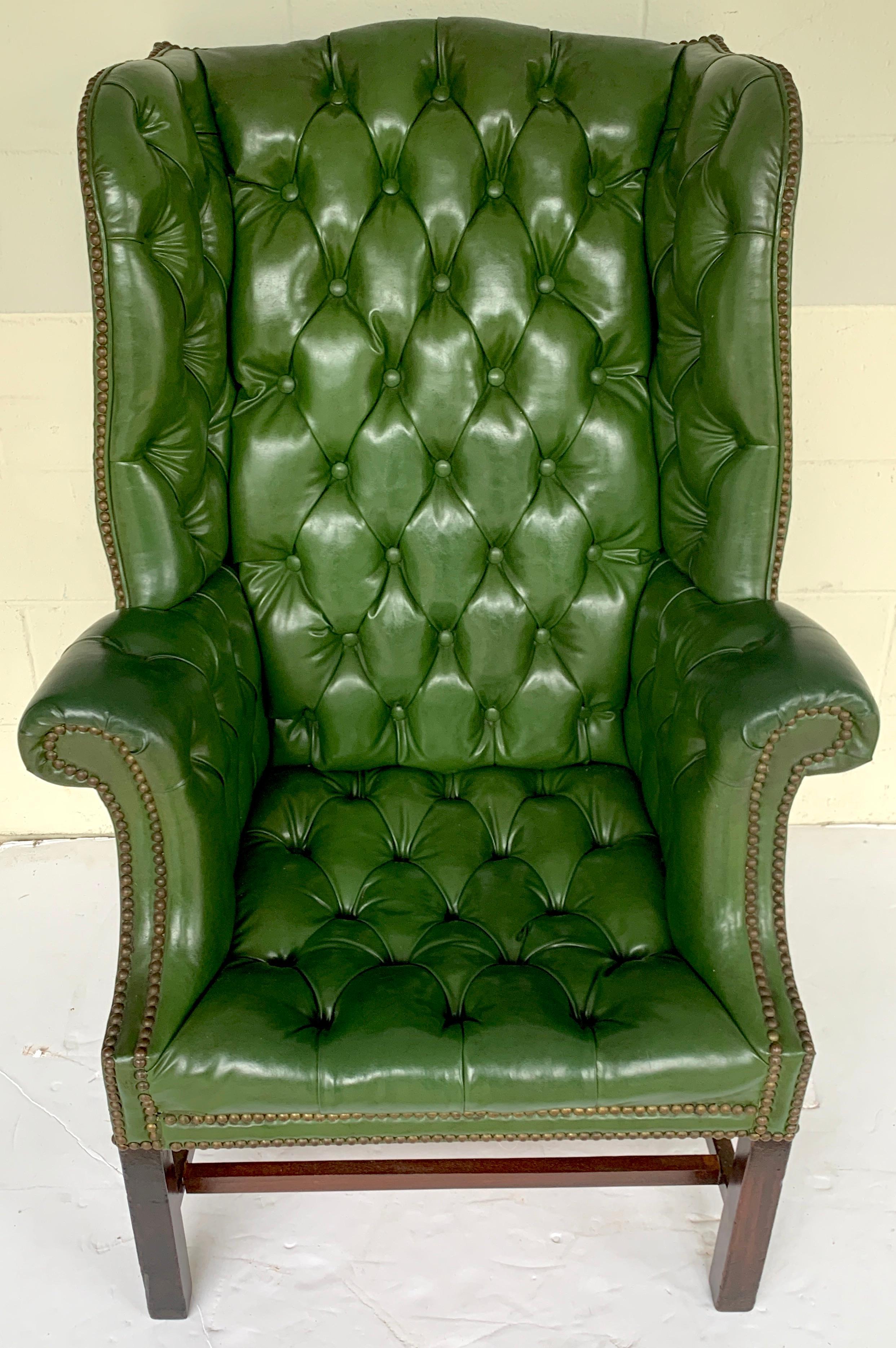 Exquisite George III mahogany green leather chesterfield wing chair, old world proportions, with tall back and generous rolled arms supported on an exterior mahogany stretcher. The seat measures 19