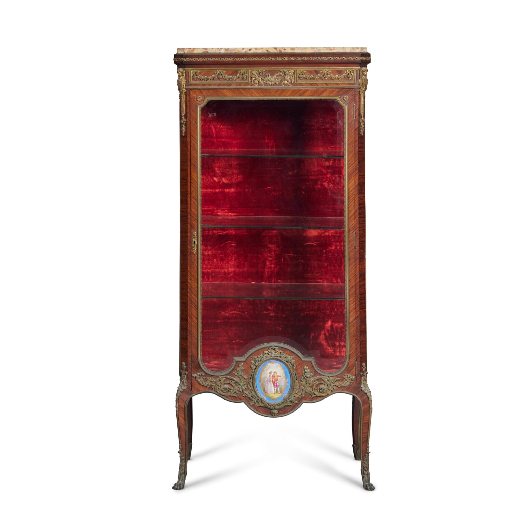 An exquisite Louis XV/Louis XVI Transitional style vitrine by the renowned French cabinetmaker François Linke from the late 19th century. Crafted in kingwood and mahogany, this fine piece is adorned with gilt bronze mounts and topped with Brèche