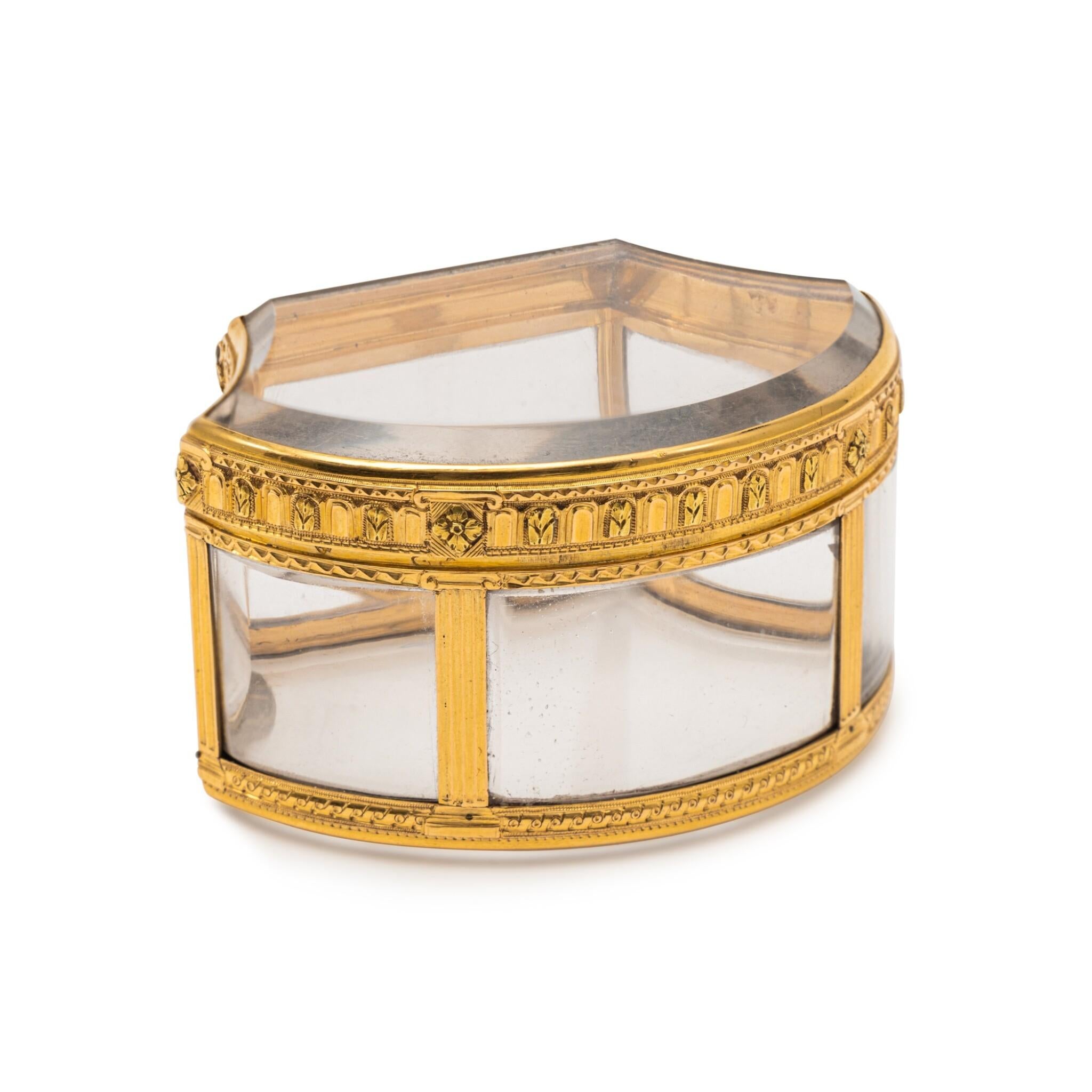 This stunning snuff box showcases exquisite craftsmanship, characterized by its elegant shell outline and intricately shaped panels. The panels are beautifully mounted in a cage, supported by fluted pilasters that add a touch of sophistication to