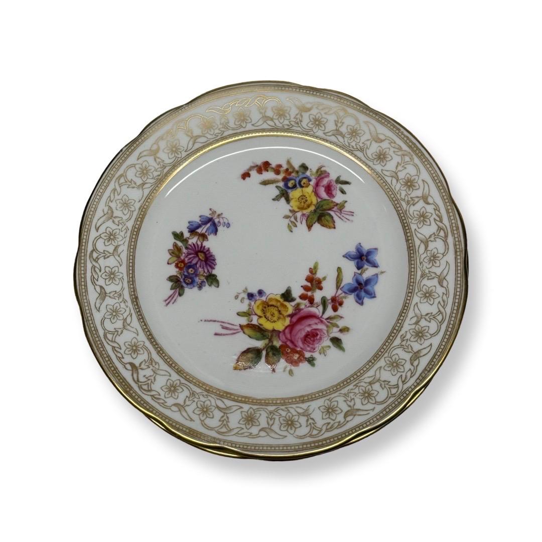 Ce superbe set d'assiettes à dessert en porcelaine de Hammersley & Co. met en valeur l'art et le savoir-faire raffinés synonymes de ce fabricant anglais de renom. D'un diamètre de 13 cm, ces assiettes présentent au centre un époustouflant motif