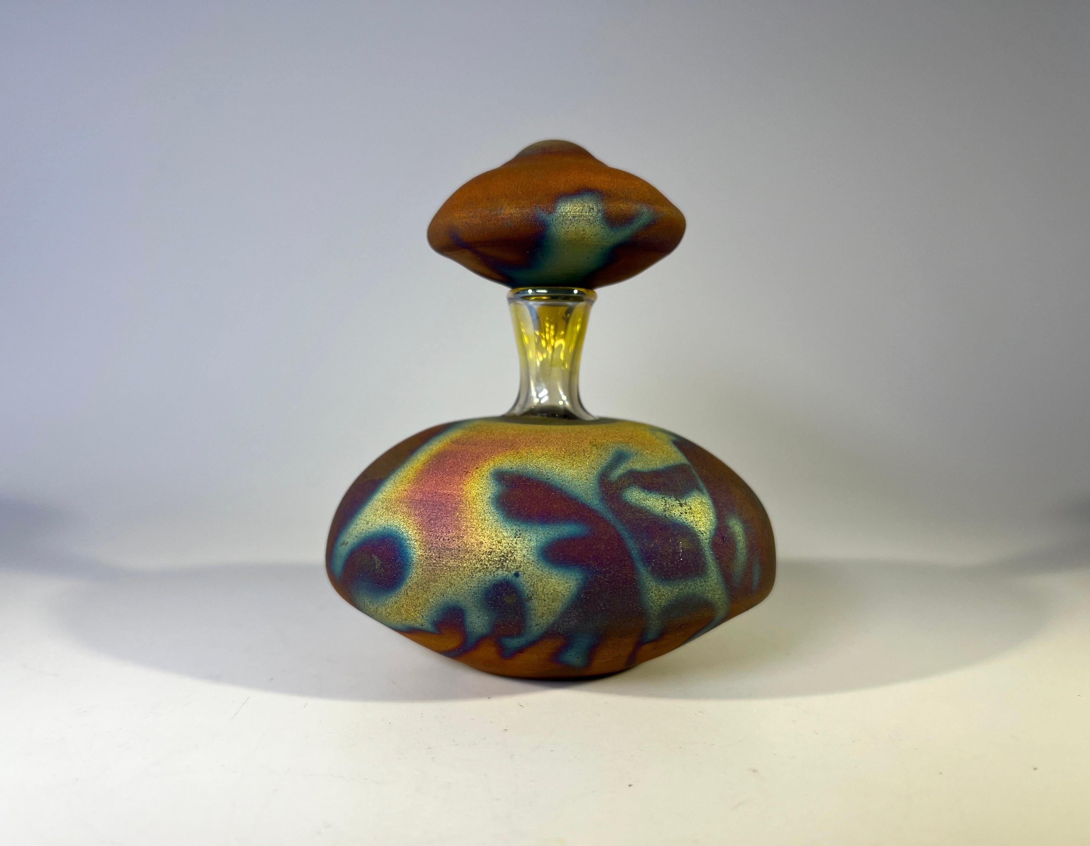 Fascinating, elegant and unique hand blown glass perfume bottle
Wonderful lustres with matt cocoa dust copper and muted gold colourings 
Incredibly delicate in design. 
Stopper has a perfect glass dabber
Signed to the base
Circa 1980's
