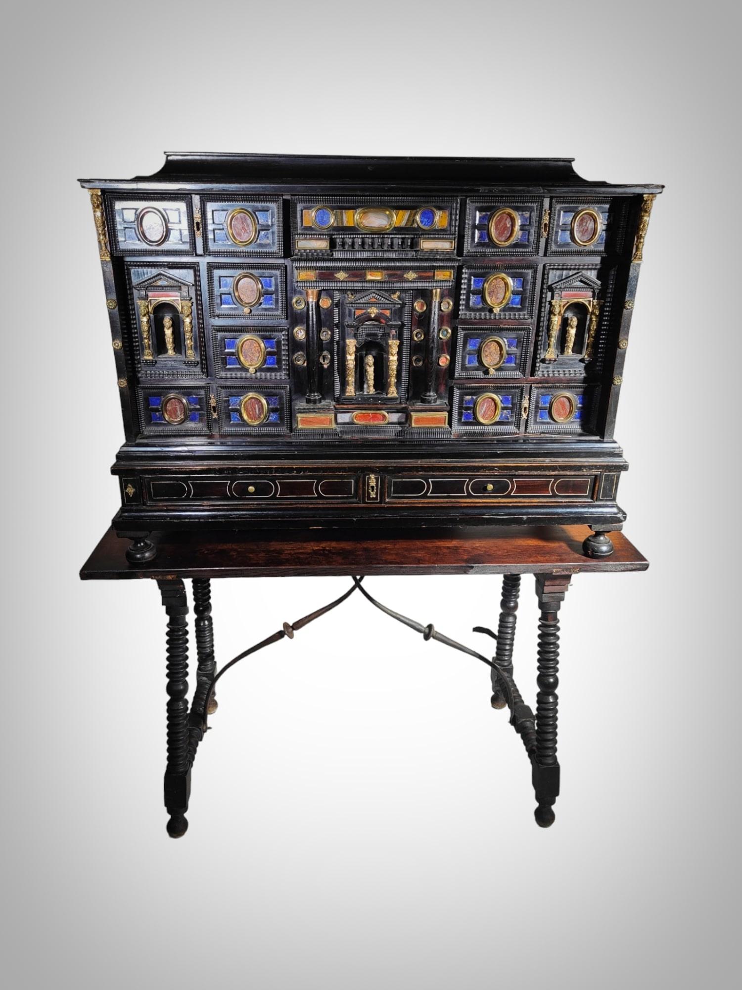 Step into the opulent world of the Italian Baroque era with this extraordinary 17th-century cabinet. Meticulously crafted with unparalleled artistry, this ebony and ebonized cabinet boasts a breakfront architectural design, adorned with the richness