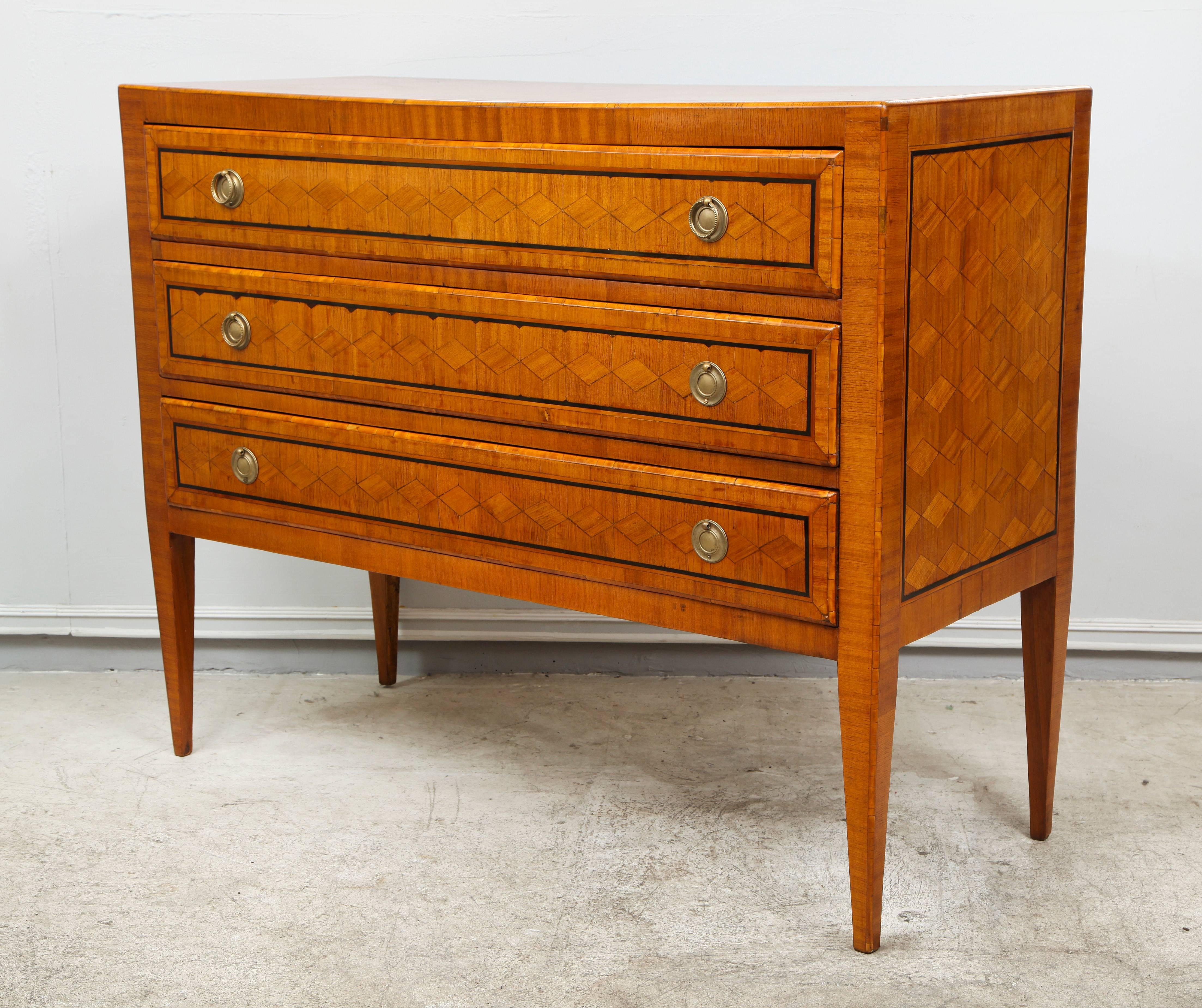 Exquisite Italian parquetry commode in the neoclassical manner with three pull-out drawers on tapered legs.
