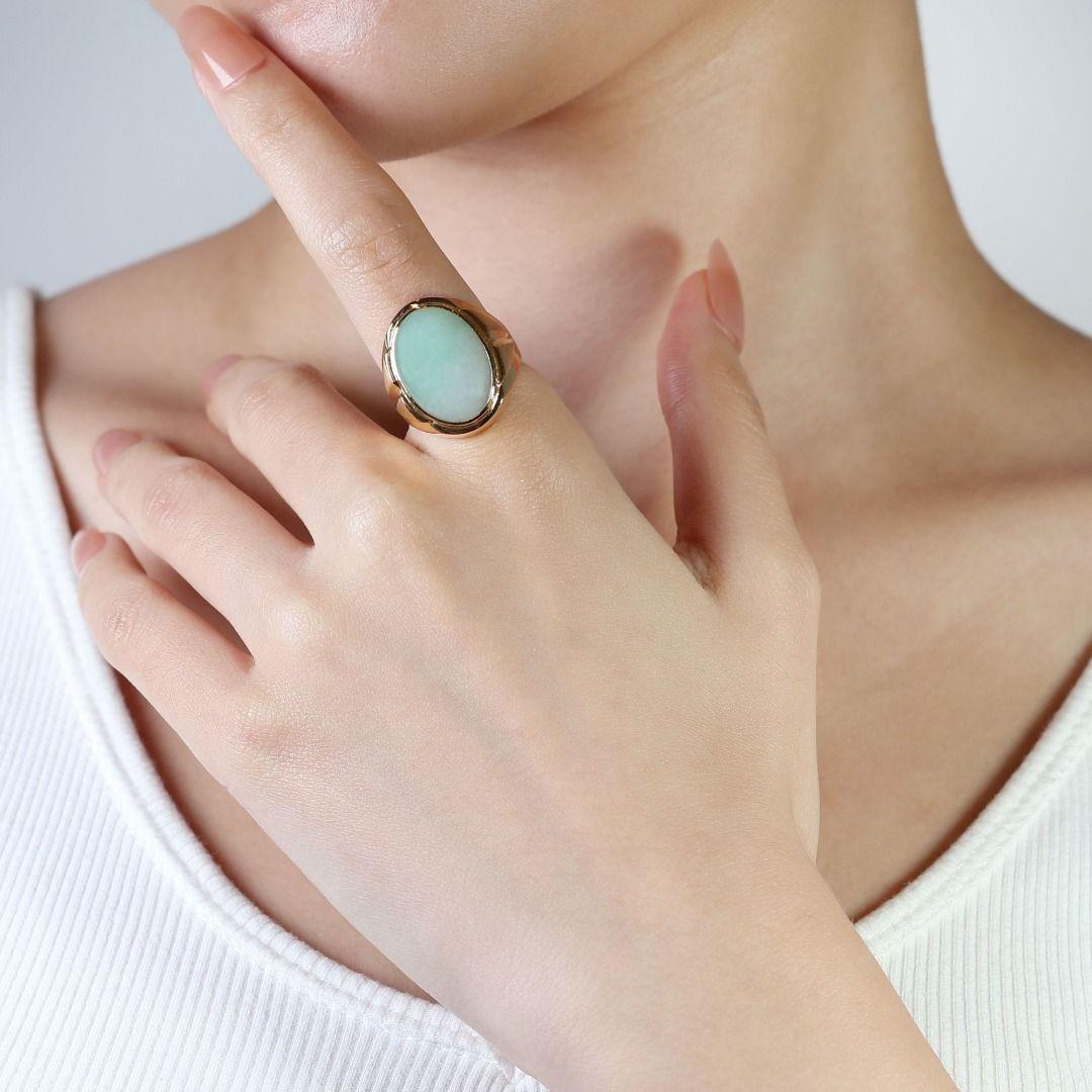 The centerpiece of this exquisite ring is a stunning cabochon-cut jade stone, boasting a remarkable carat weight of 15.40ct. The rich green hue of the jade is complemented by its smooth, polished surface, adding a touch of sophistication to the