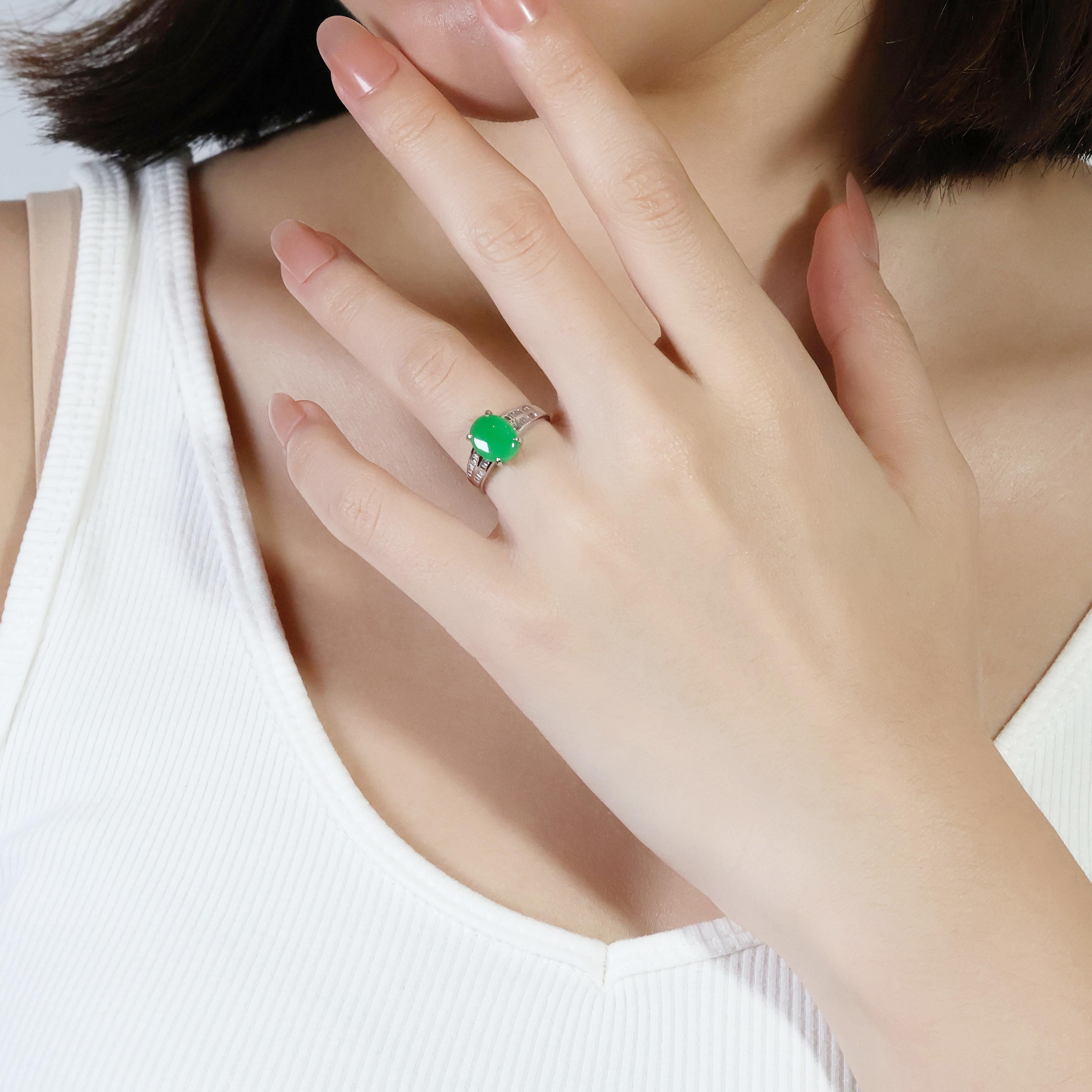 This exquisite 18K white gold ring features a stunning oval-shaped green jade as its main stone, creating a captivating centerpiece. The jade is complemented by 28 round brilliant diamonds with a total carat weight of 0.14ct, an H color grade, and