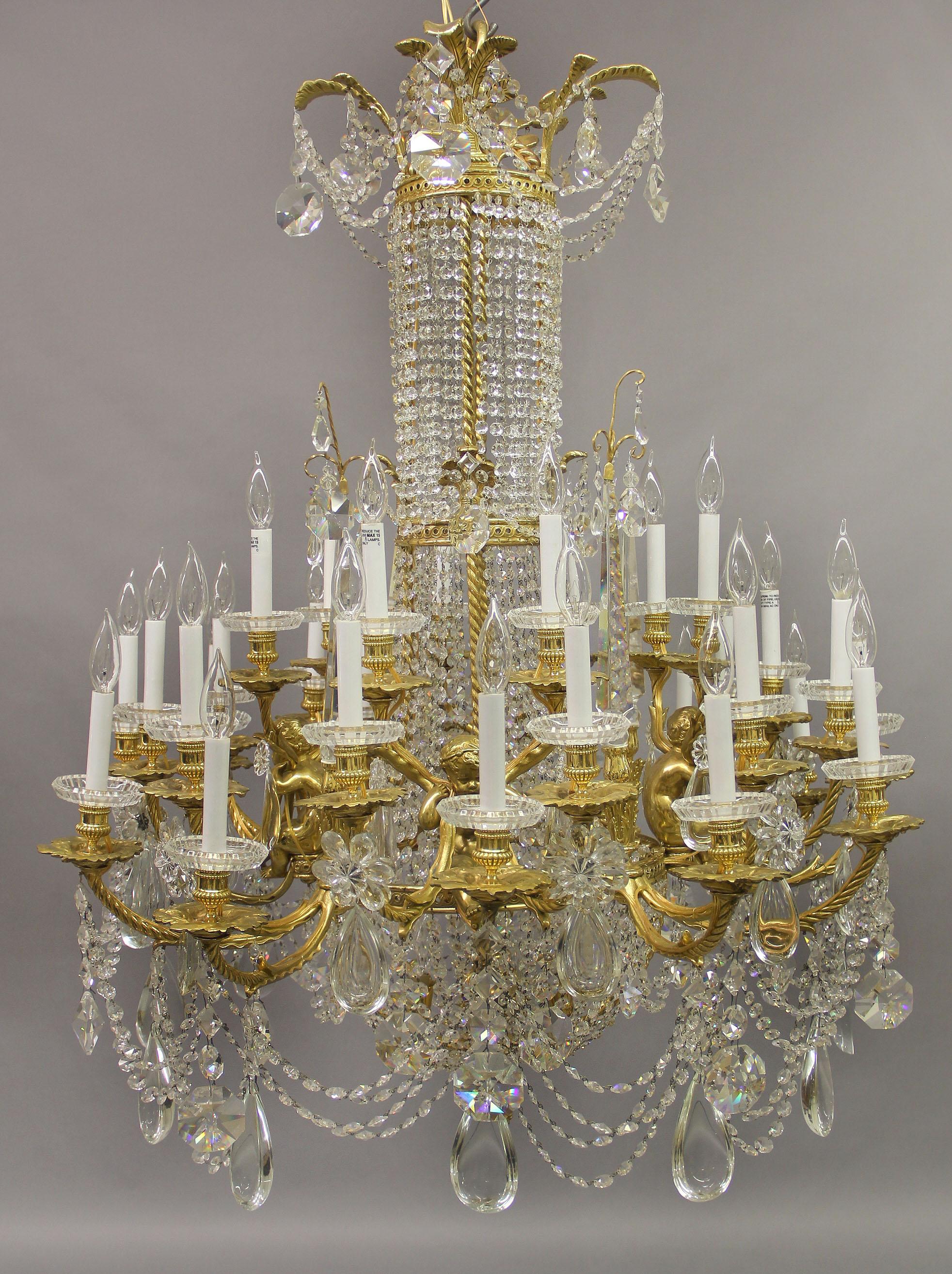 An exquisite late 19th century gilt bronze and crystal thirty six light chandelier by Baccarat

Compagnie des Cristalleries de Baccarat

The circular palm-frond and guilloché corona suspending drop chains and rope-twists supporting a similar