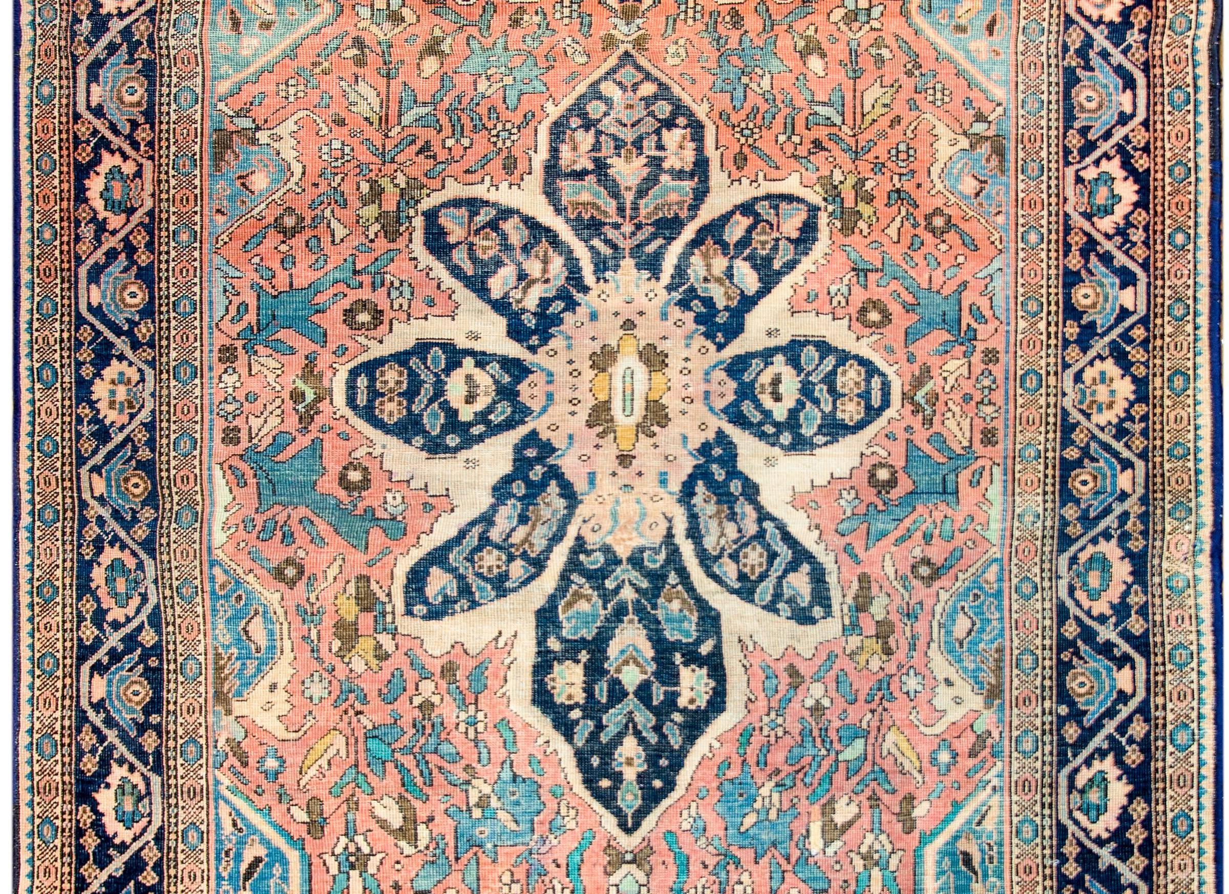 An exquisite late 19th century Persian Sarouk Farahan rug with an expertly rendered asymmetrical central floral medallion containing a pattern of leaves and flowers woven in light and dark indigo, salmon, and cream colored vegetable dyed wool. The