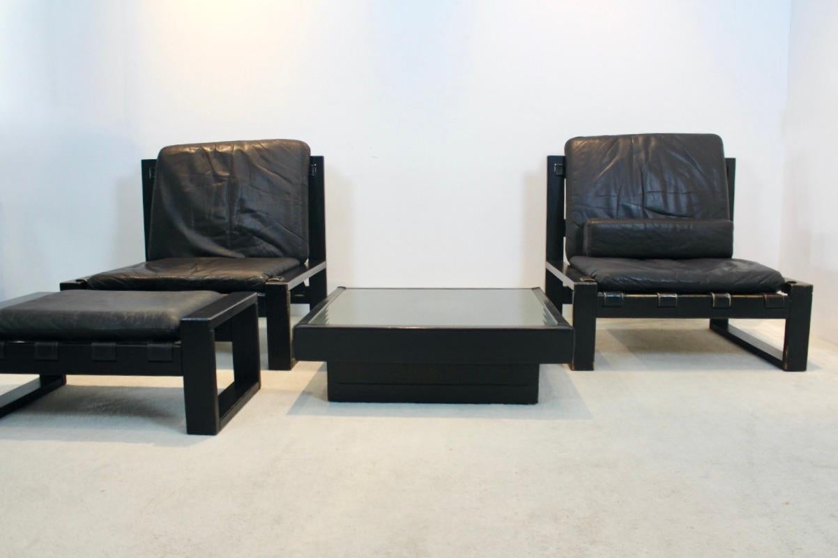 Ensemble de salon unique conçu par l'atelier Sonja Wasseur. Composé de deux chaises longues, d'un tabouret et d'une table centrale. Le tout avec une base en bois brun foncé très solide et des sièges en cuir brun chocolat. Même la table est