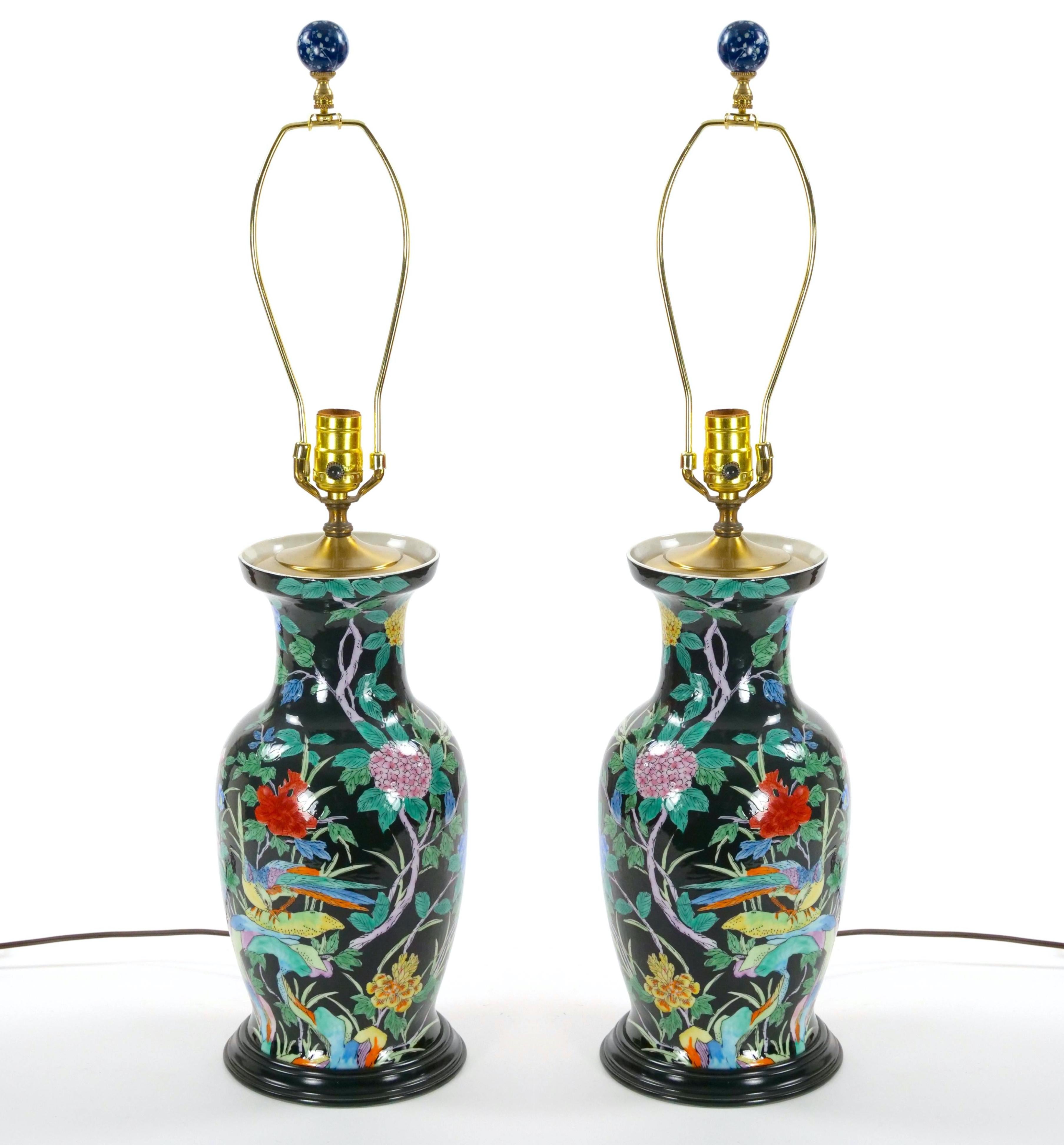Esta exquisita lámpara de mesa de porcelana famille noir china de mediados del siglo XX es un complemento impresionante para cualquier decoración. Con una elegante forma de urna y un cuello graciosamente estrechado, la lámpara muestra una intrincada