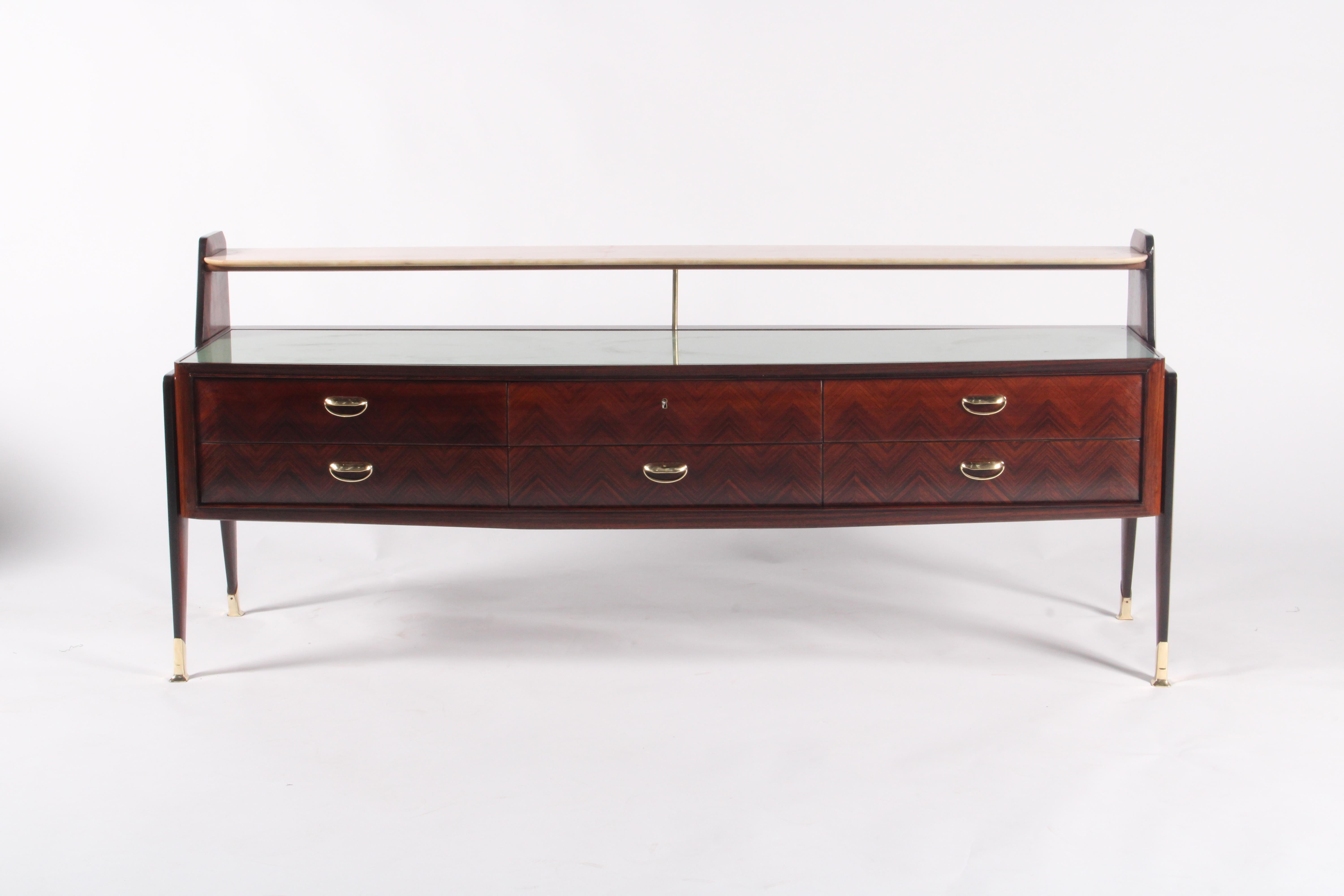 A stunning example of Italian mid-century design, this elegant rosewood sideboard exudes refinement and sophistication. The rich, warm tones of the rosewood are enhanced by a subtle chevron grain pattern across its six drawers, each adorned with