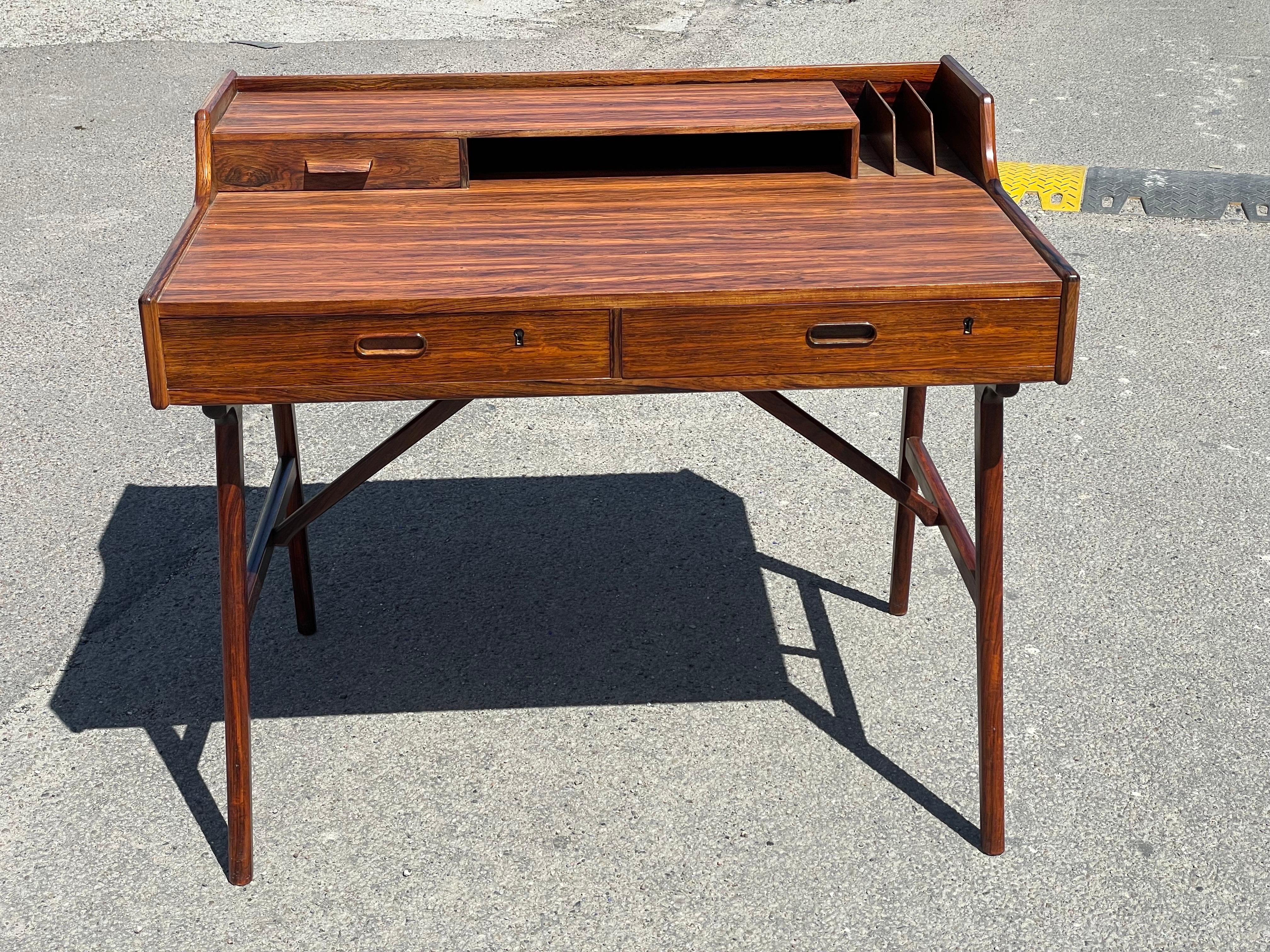 A desk in rosewood veneer designed by Arne W. Iversen and edited by Vinde Mobelfabrik in the 1970s.Top with drawer; compartiment and letter sortens, front with two drawers.