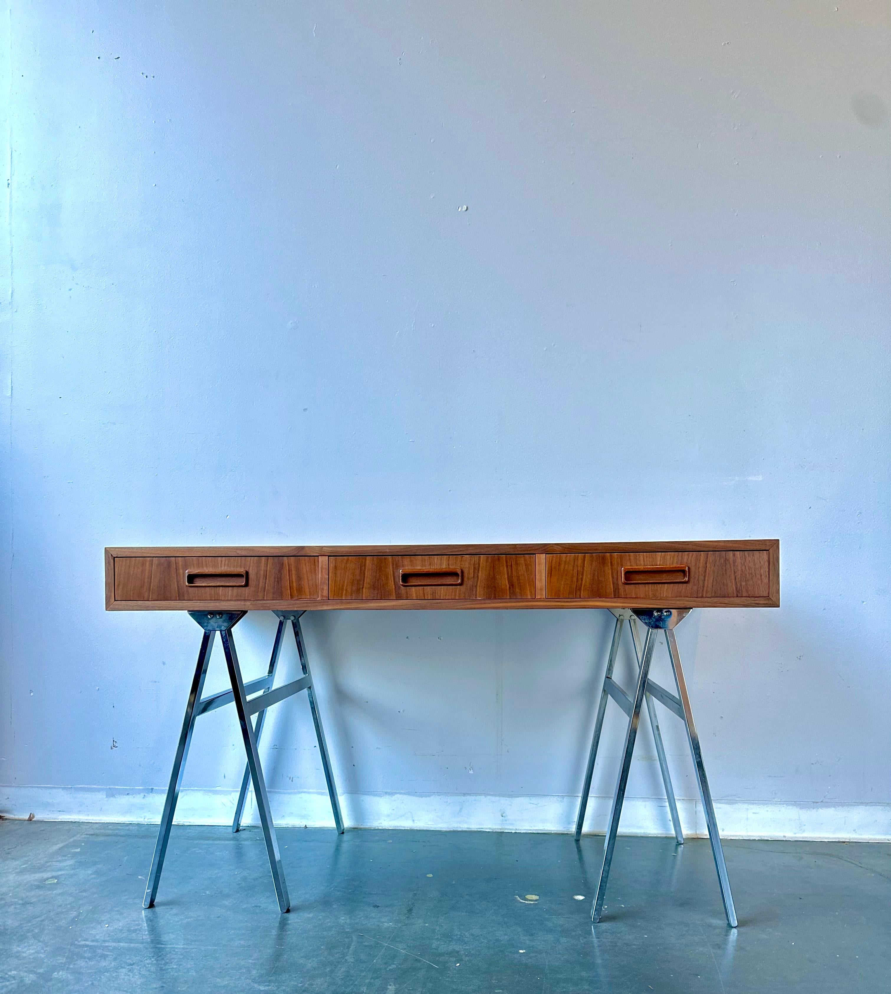This stunning walnut and steel sawhorse style vintage 1960s desk has been refinished and is ready to be enjoyed. Featuring a finished back so you can float this unique desk in the middle of your room. maker is unknown but this rare desk is very well