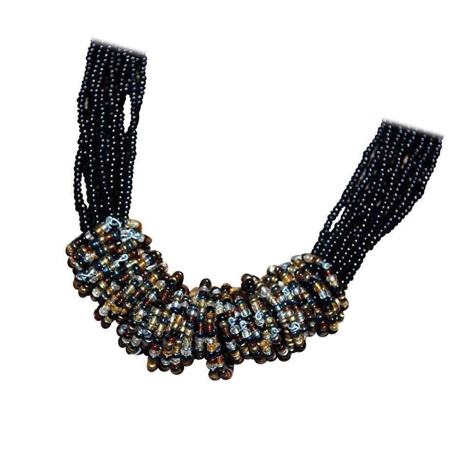 Stunning Handmade Runway Necklace consists of multiple black beaded strands surrounded by dozens of individual rings in a combination of bronze, black, gold, clear, and silver beads of various shades.  Approx. adjustable length: 18-20 inches.