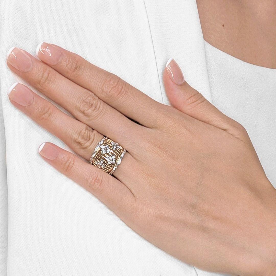 Kühn und doch feminin präsentiert sich dieser breite Ring mit einer verspielten Mischung aus Textur, Glanz und Handwerkskunst. Das aus zweifarbigem 18-Karat-Gold gefertigte Design zeichnet sich durch eine durchbrochene Basis aus Gelbgold aus, die