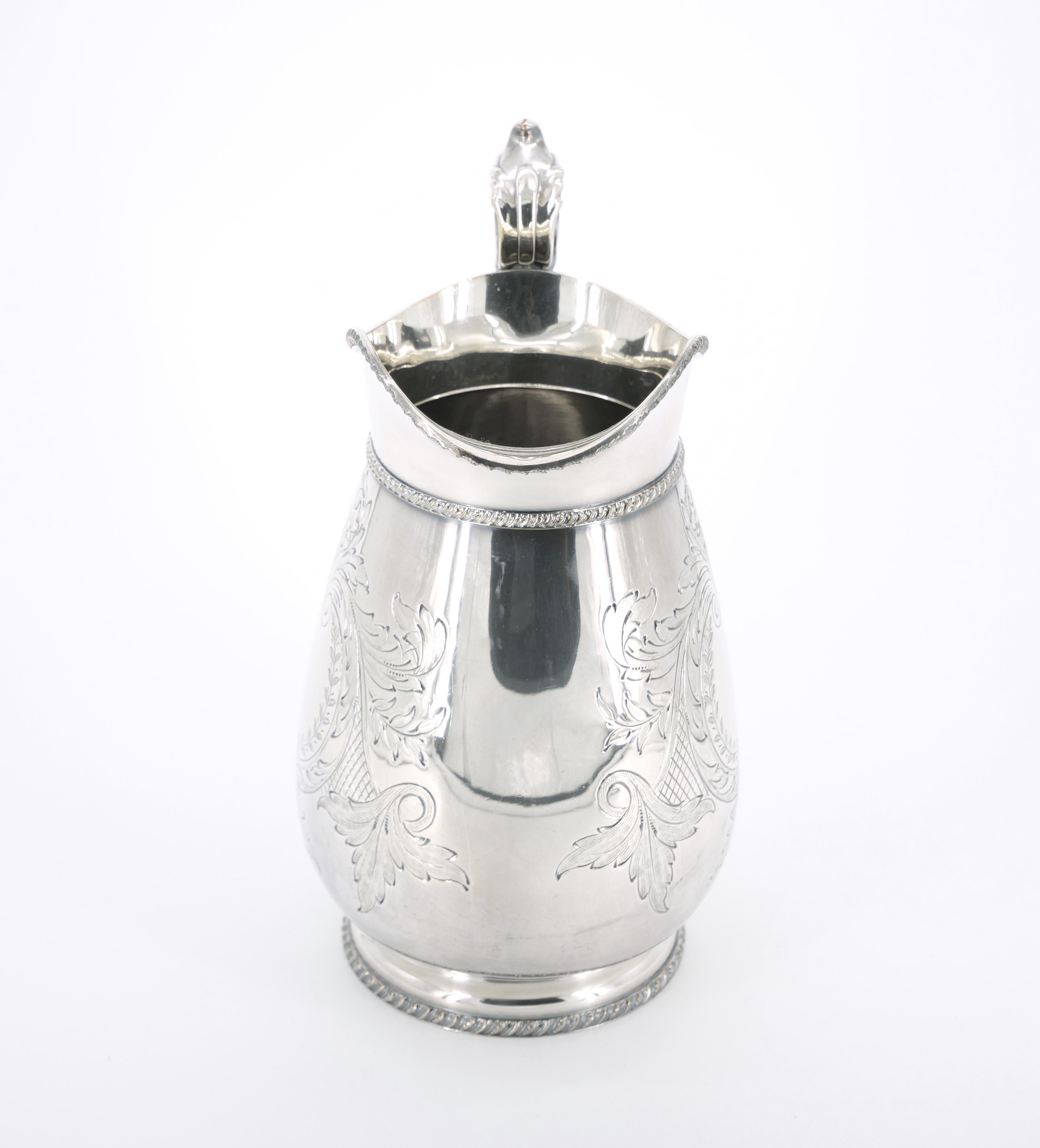 This exquisite Old English silver-plated serving pitcher combines timeless elegance with intricate detail, making it a perfect addition to tableware or barware collections. The exterior is adorned with meticulously engraved floral designs,