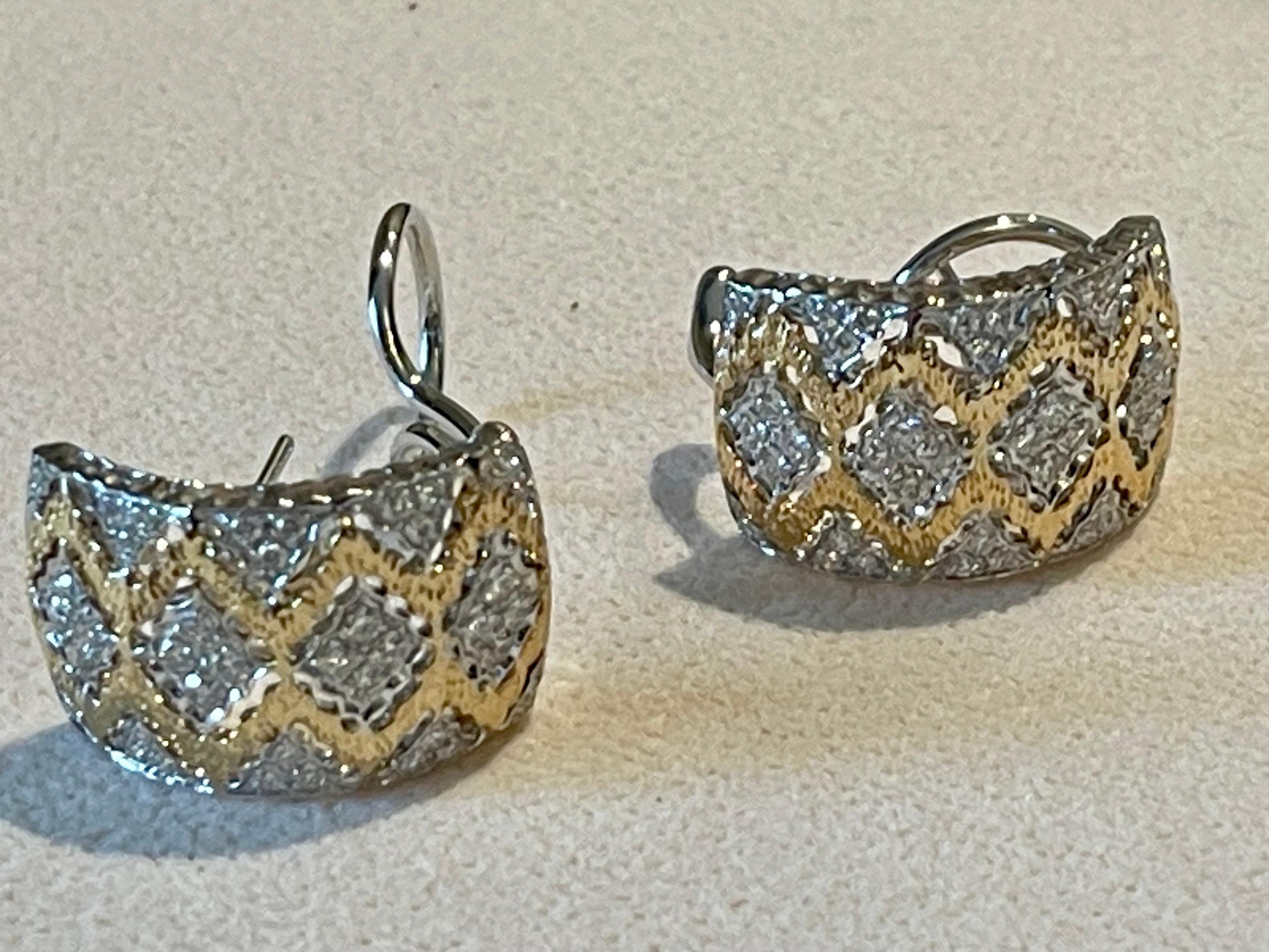 Ein Paar zweifarbiges 18 K. Gelbgold und 18 K. Weißgold  Huggies-Ohrringe mit schönem durchbrochenem Filigran zwischen den diamantförmigen Goldteilen.
In der Mitte jedes Abschnitts befindet sich ein Diamant im Brillantschliff. Das Gelbgold an den