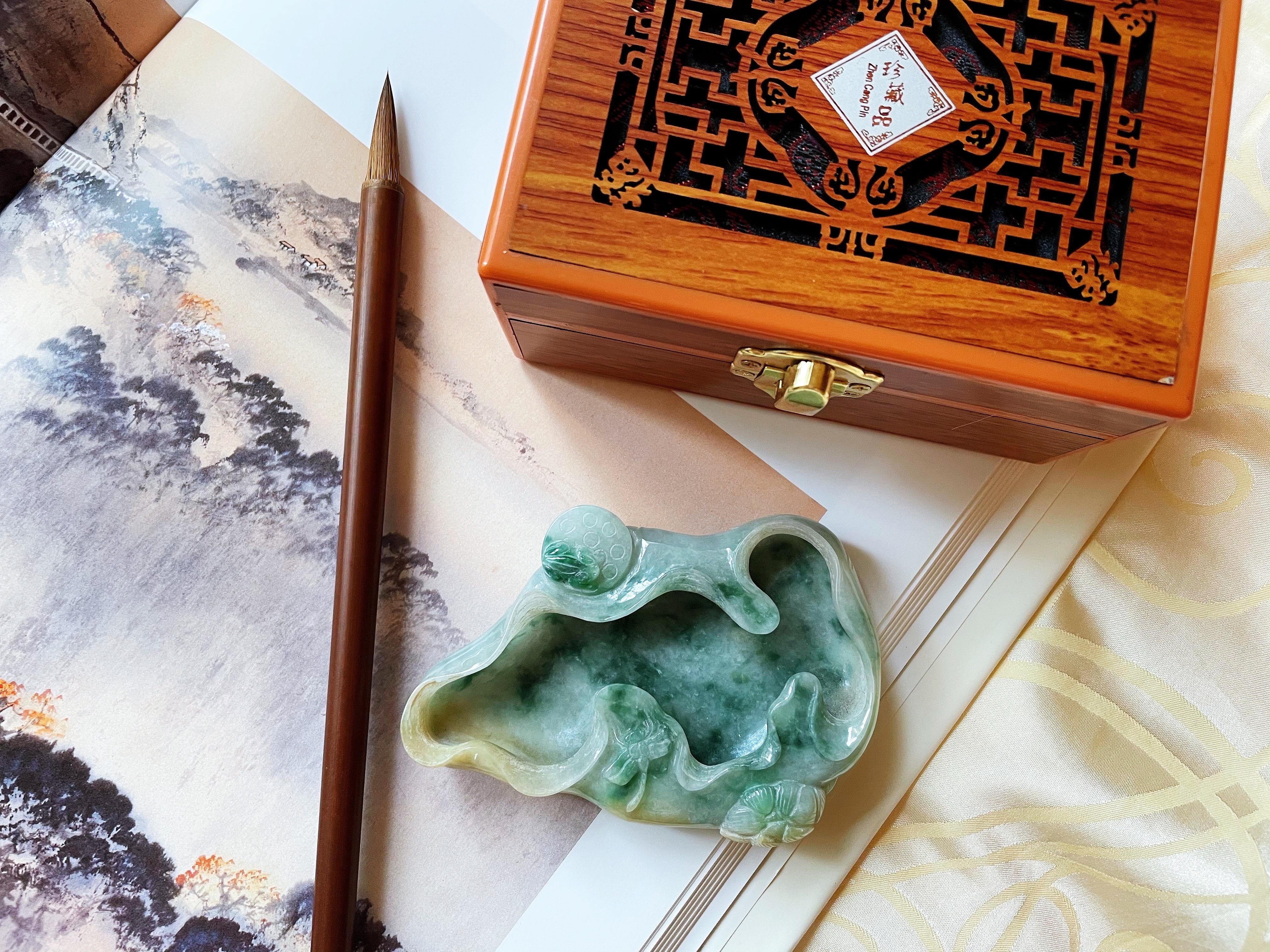 Lasciati sedurre dalla bellezza della calligrafia tradizionale cinese con questo squisito piatto per inchiostro, intagliato a mano con giada verde naturale di tipo A del Myanmar. I colori e i motivi unici della giadeite rendono ogni pezzo unico e