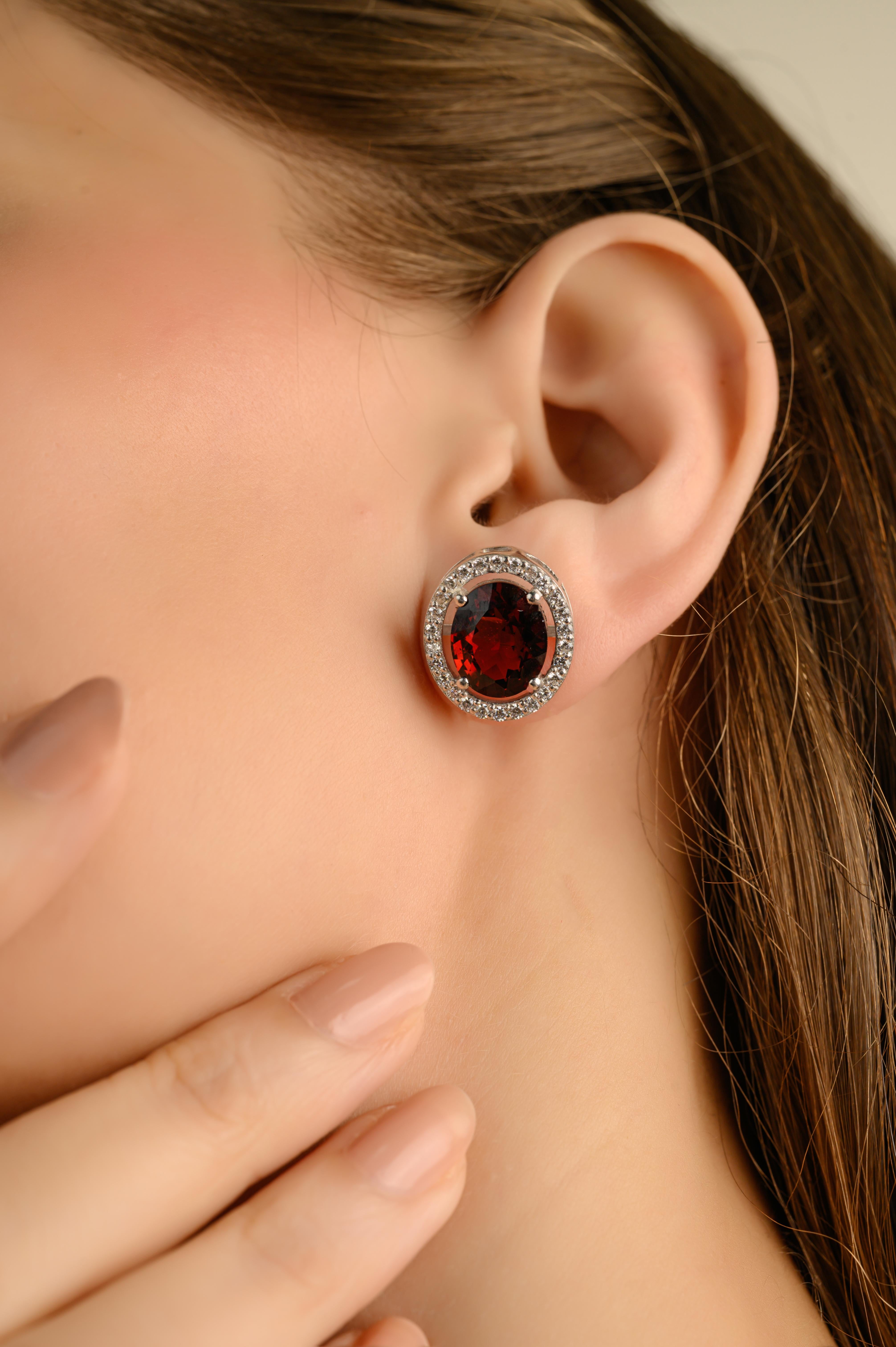 Questi orecchini a perno di ispirazione vintage con granato rosso e zircone a raggiera sono realizzati in argento 925. Ogni orecchino presenta una gemma rossa dal taglio profondo e ovale, che evoca un granato o un rubino, sapientemente incastonata