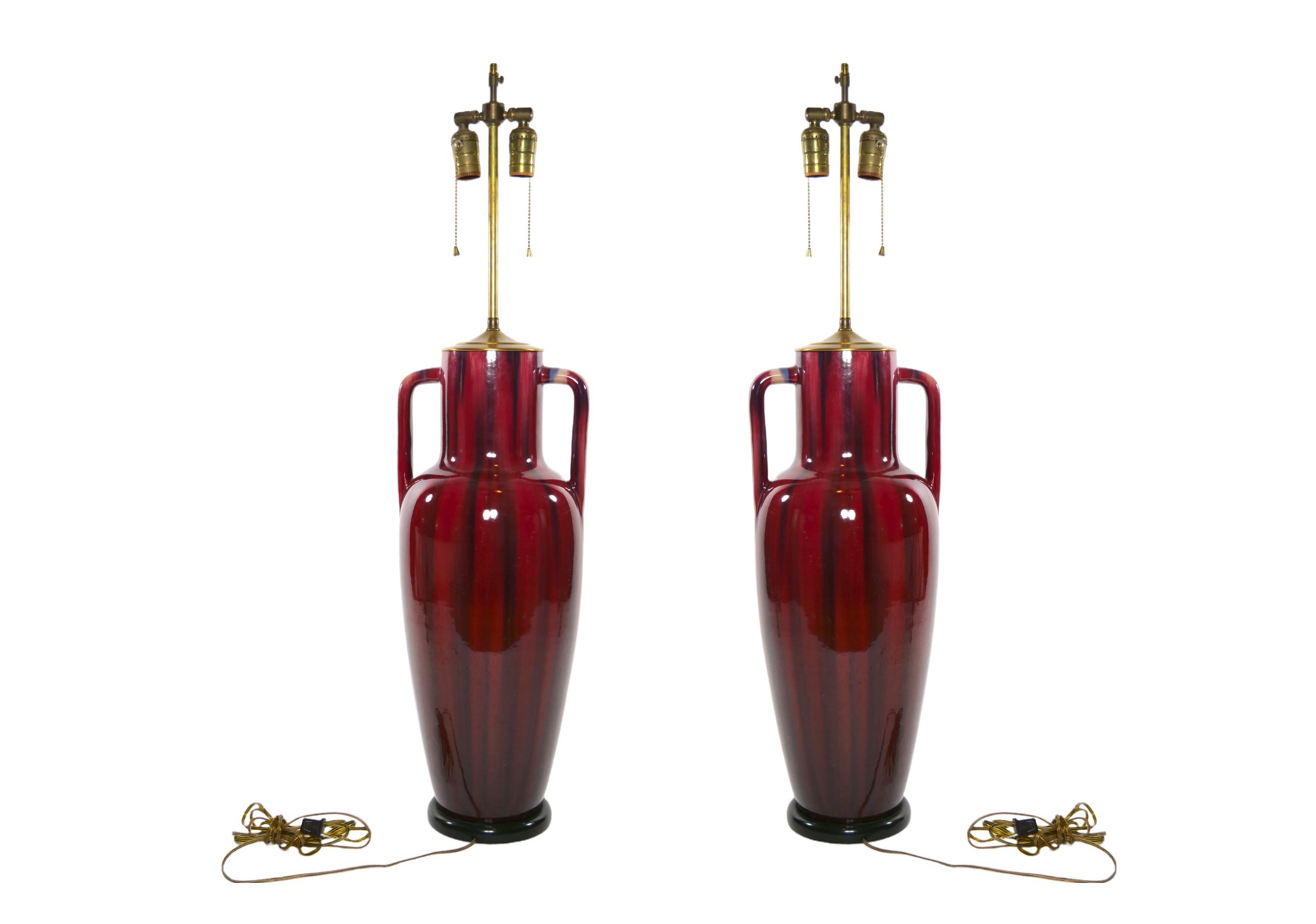 Pair glazed flambe porcelain with black wood base decorative temple jar vases mounted as table lamps. Each lamp features a narrow temple neck with two side handles resting on a round wood base. Each lamp is in good working condition. Minor wear