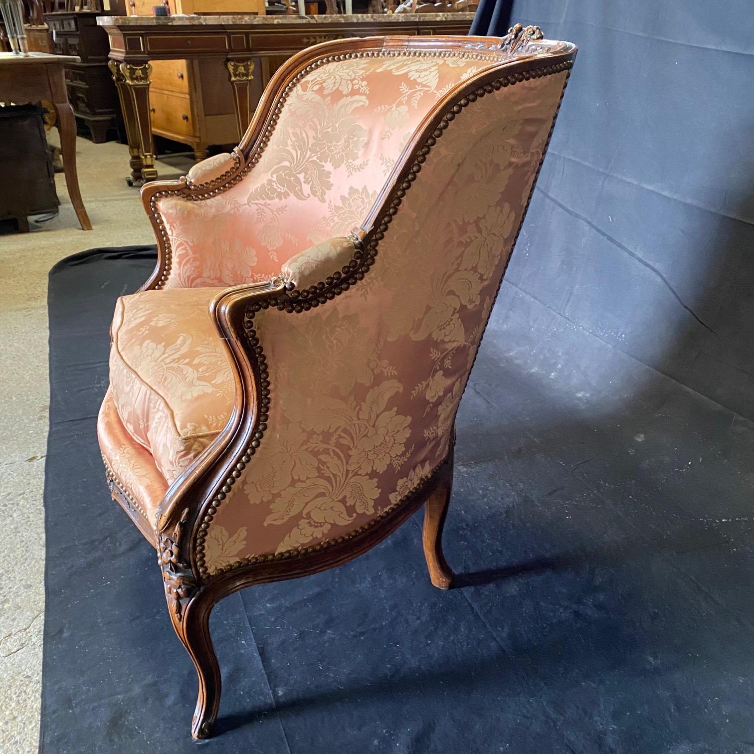 Finely carved pair of walnut French Louis XV bergere chairs with lovely damask upholstery and original brass tacking. Bought in the South of France.  #6398