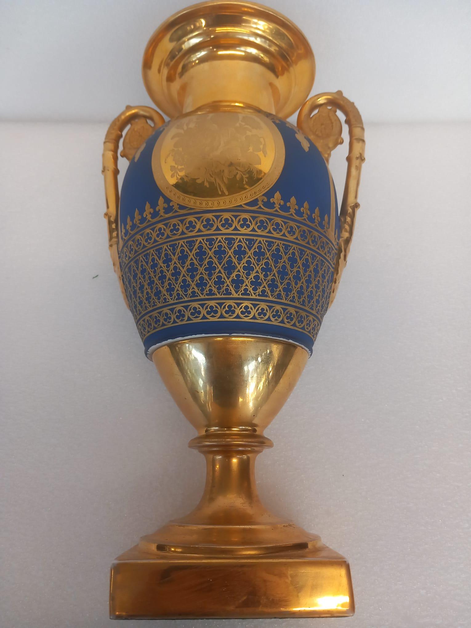 This is a fantastic pair of Bleu de Roi Paris porcelain vases, dating to the first quarter of the nineteenth century, most likely crafted during the reign of Napoleon I (circa 1810-1815). These vases are emblematic of Napoleonic style, featuring
