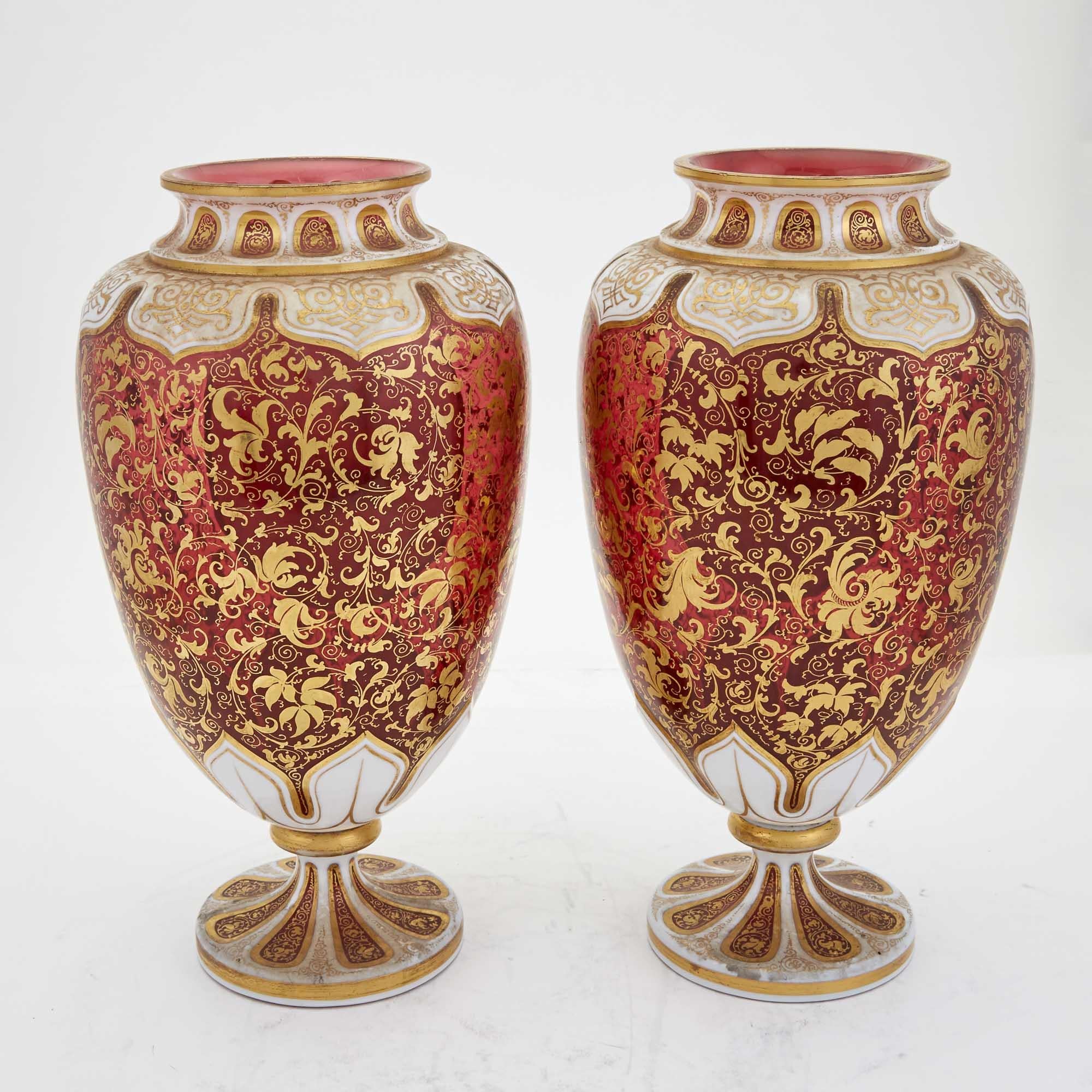 Coppia di vasi da ritratto in vetro rosso rubino con smalto bianco,  ornamenti dipinti in oro e ritratti stampati in litografia. La Bohemia, oggi conosciuta come Repubblica Ceca, è famosa per i suoi vetri decorativi, prodotti nella regione fin dal