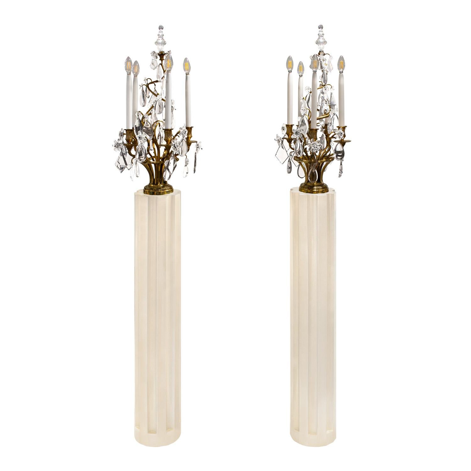 Coppia di imponenti e splendide lampade da terra a candelabro, ciascuna a 5 luci, in bronzo inciso e ornate da cristalli sfaccettati su basi scanalate con piedistallo laccato avorio, Francia anni '50.  I grandi terminali in cristallo sono originali.