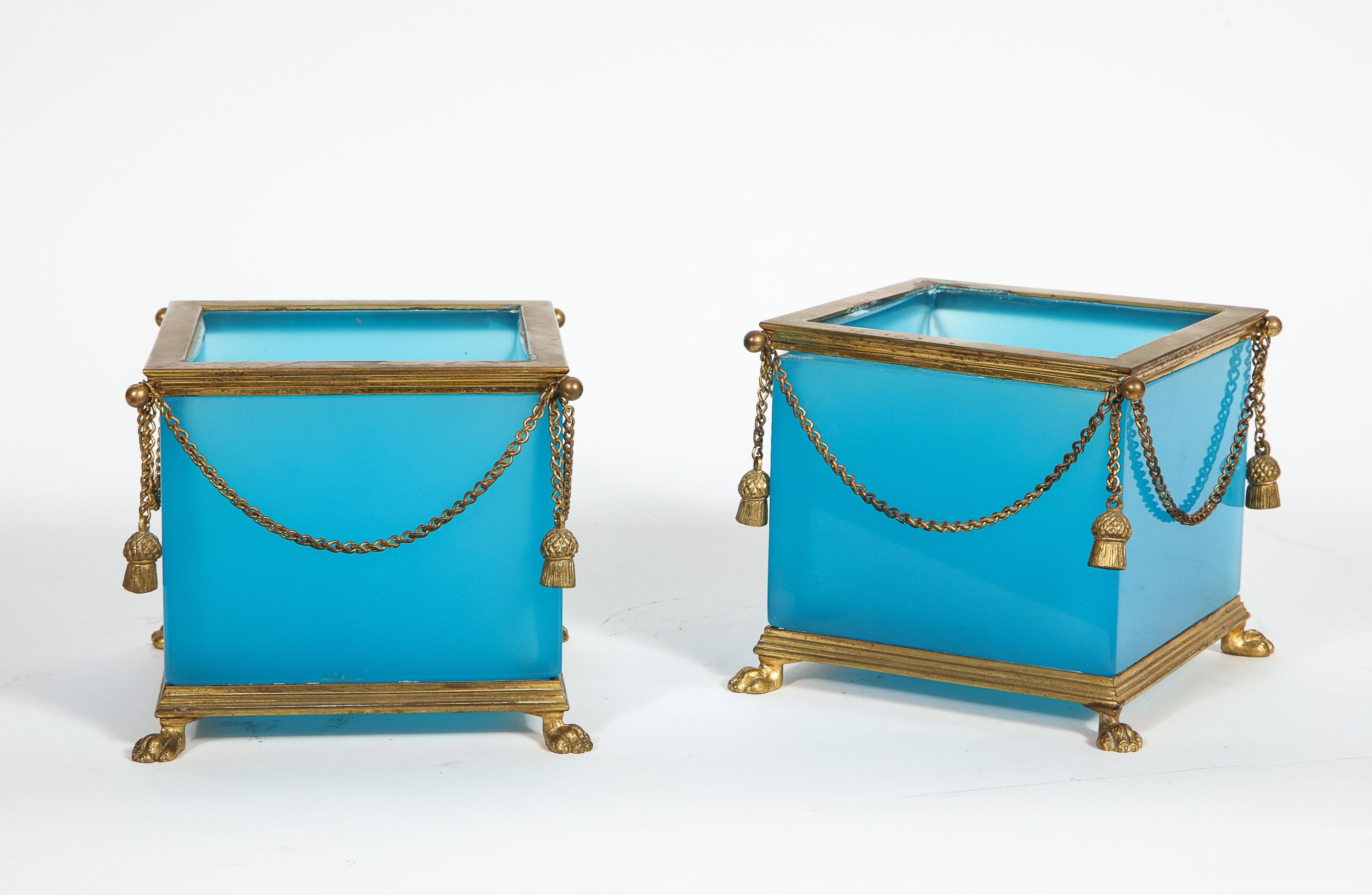 Exquisite and very elegant pair of French ormolu-mounted turquoise blue opaline glass jardinières cache pots, attributed to Baccarat, paris, circa 1870.

Each of square form, the stepped rim with suspending chains and pendant tassels, raised on