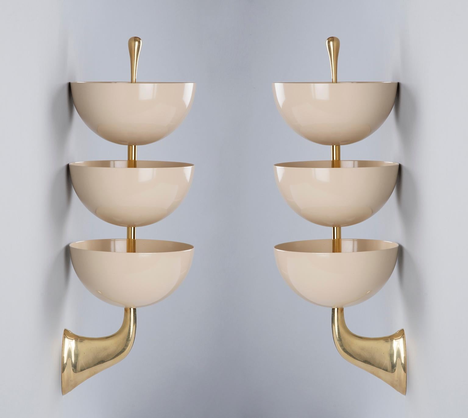 A rare and incredibly graceful pair of tiered sconces by Stilnovo with three enameled bowls in eggshell white mounted on sculptural and tapering polished brass mounts with a rounded teardrop finial.

Signed. 

Italy, 1950's.

Rewired for use in the
