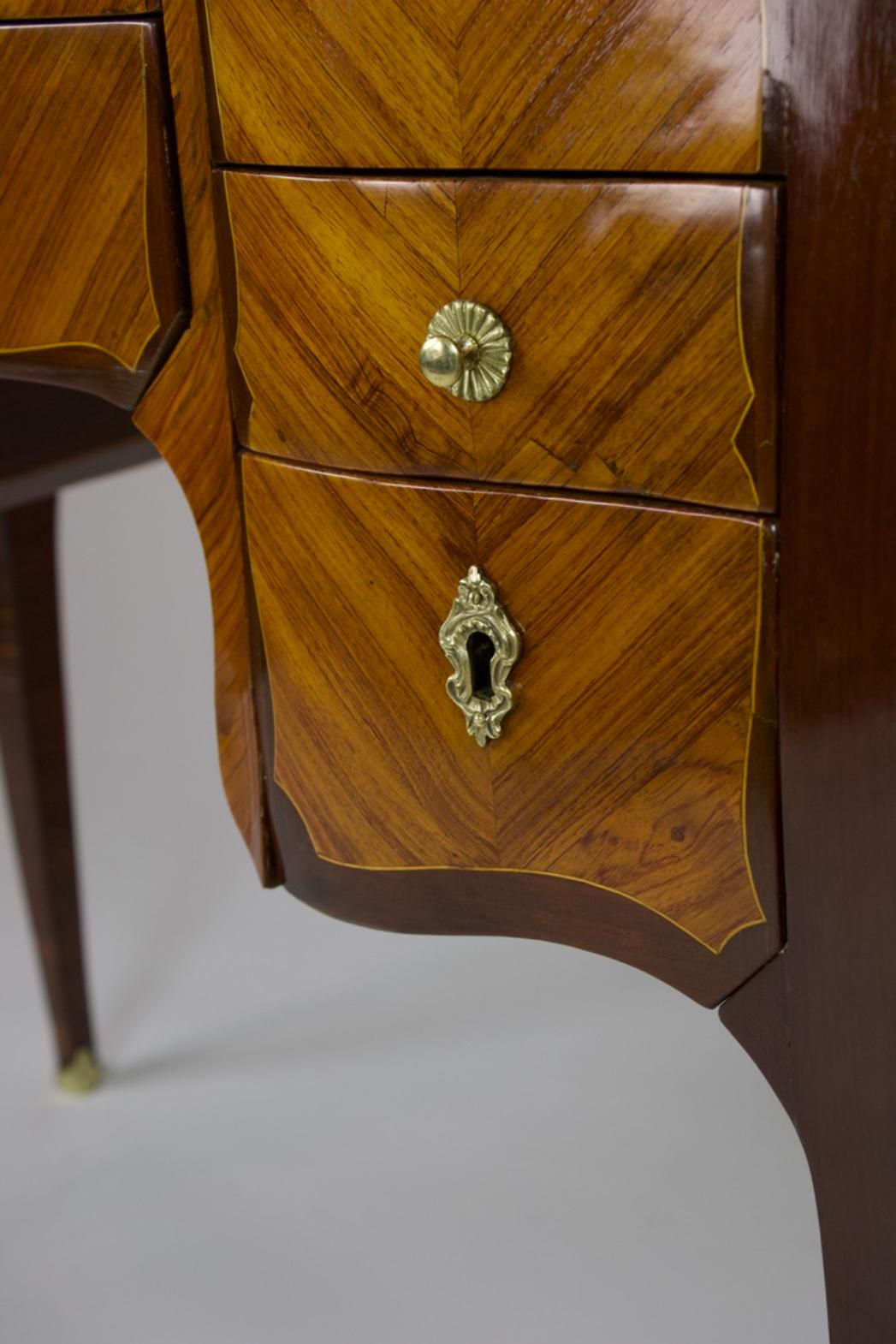 Questo squisito Kabinettmöbel nasce da una storia di storia dell'arte che si svolge tra il Verspielten Rokoko e il Frühen Neoklassizismus. L'elegante Poudreuse unisce le linee morbide di Luigi XV con la simmetria di Luigi XVI e si distingue per la