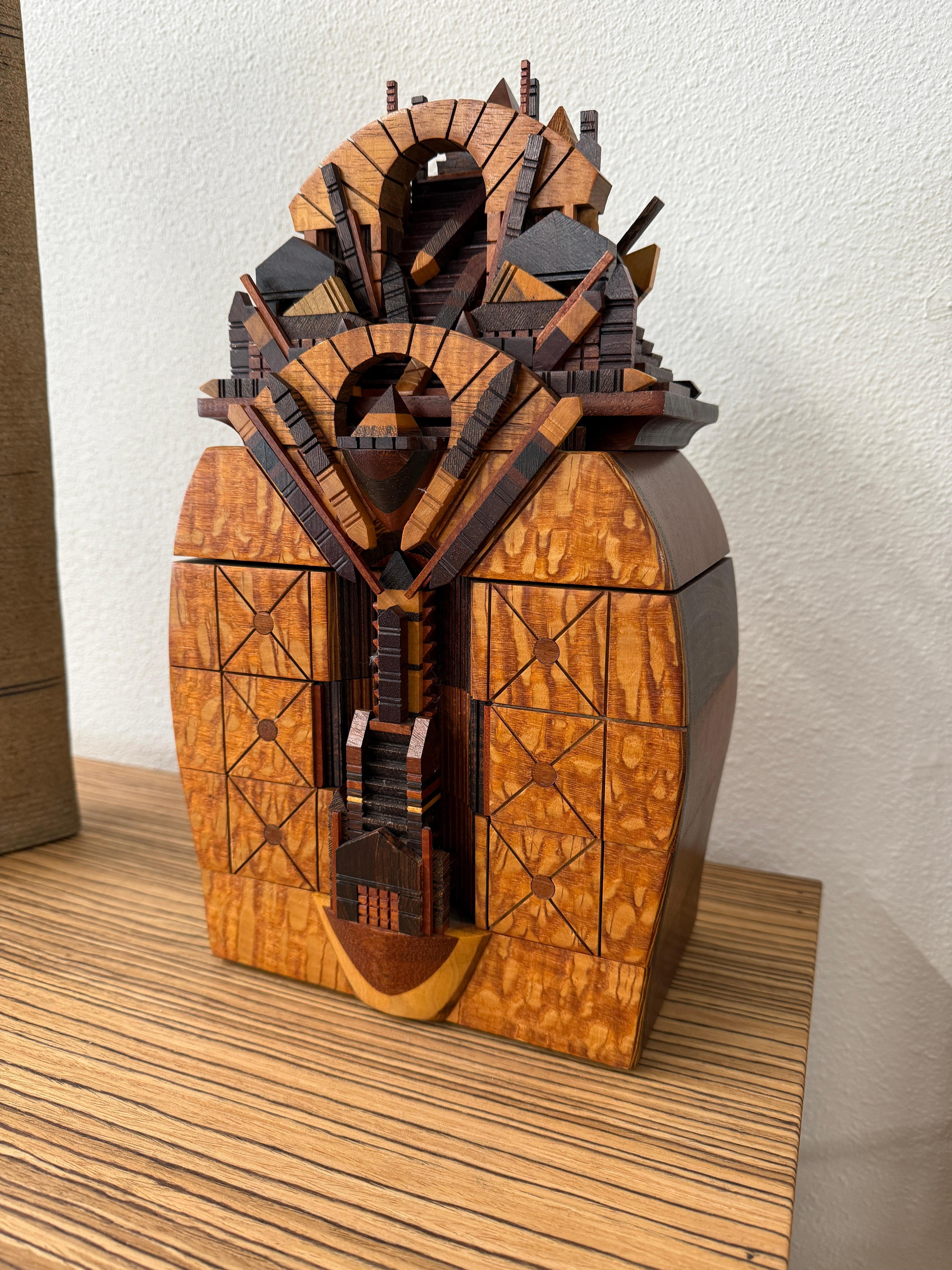 Une boîte à bijoux ou décorative exquise réalisée par le célèbre artisan californien Po Shun Leong. Cette boîte est fabriquée à partir de nombreux bois exotiques. La partie supérieure se soulève pour révéler un compartiment caché. Magnifiquement