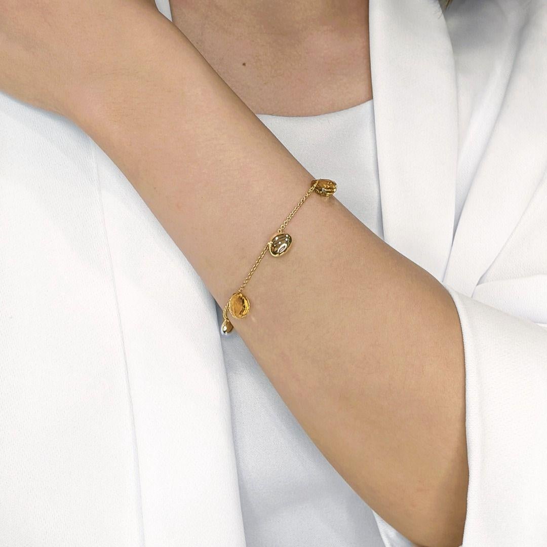 Radiating a golden glow, this elegant 18K yellow gold bracelet features three captivating rose-cut citrine gemstones, each showcasing a mesmerizing orange hue that evokes warmth and vibrancy. The timeless design allows the natural beauty of citrine