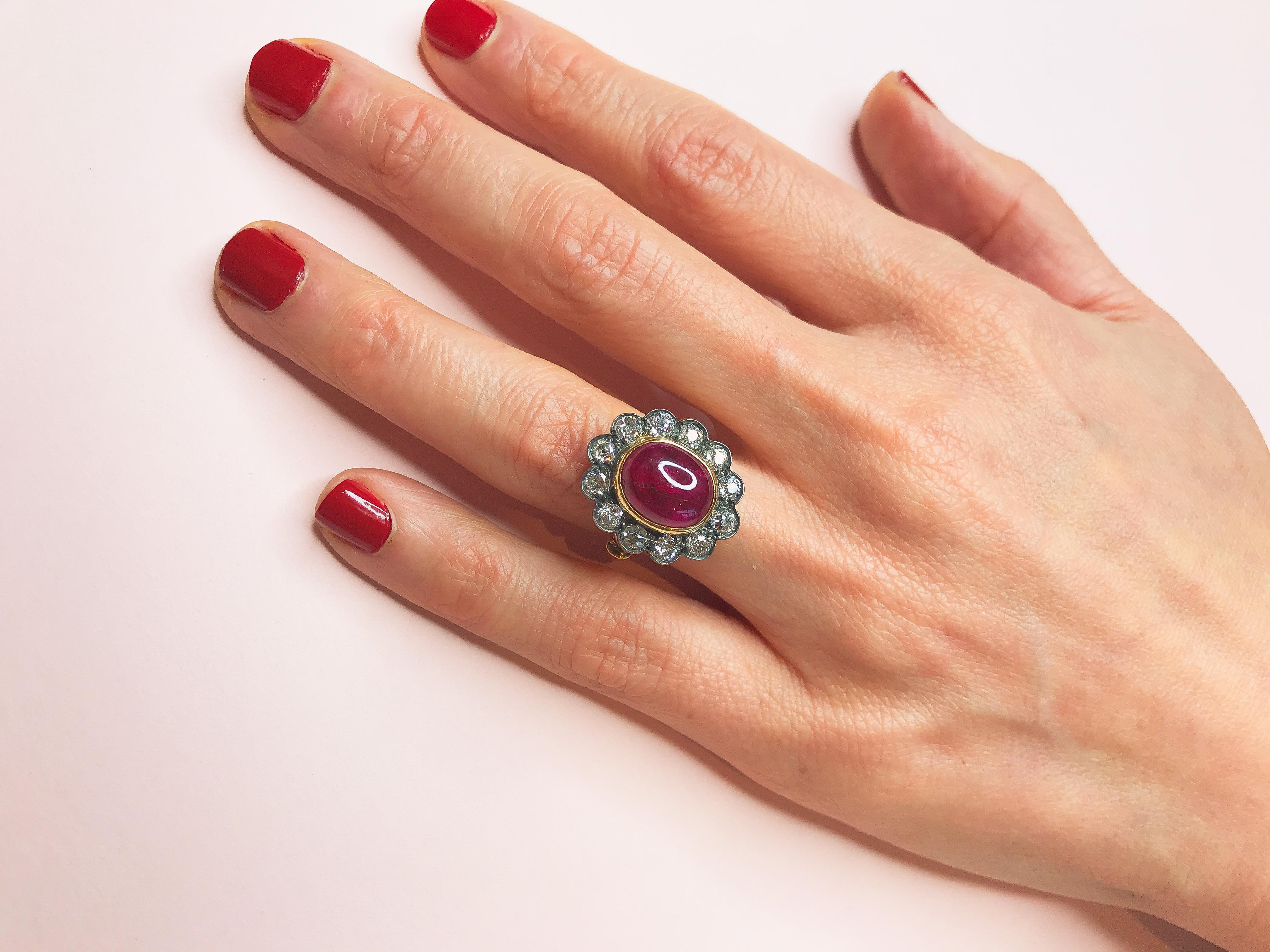 Der handverlesene Cabochon-Rubin in der Mitte dieses Rings im Vintage-Stil verschlägt Ihnen dank seiner Größe und seiner charmanten rosaroten Farbe den Atem. Der Halo, der ihn umgibt, besteht aus runden weißen Brillanten, die in reichhaltiges