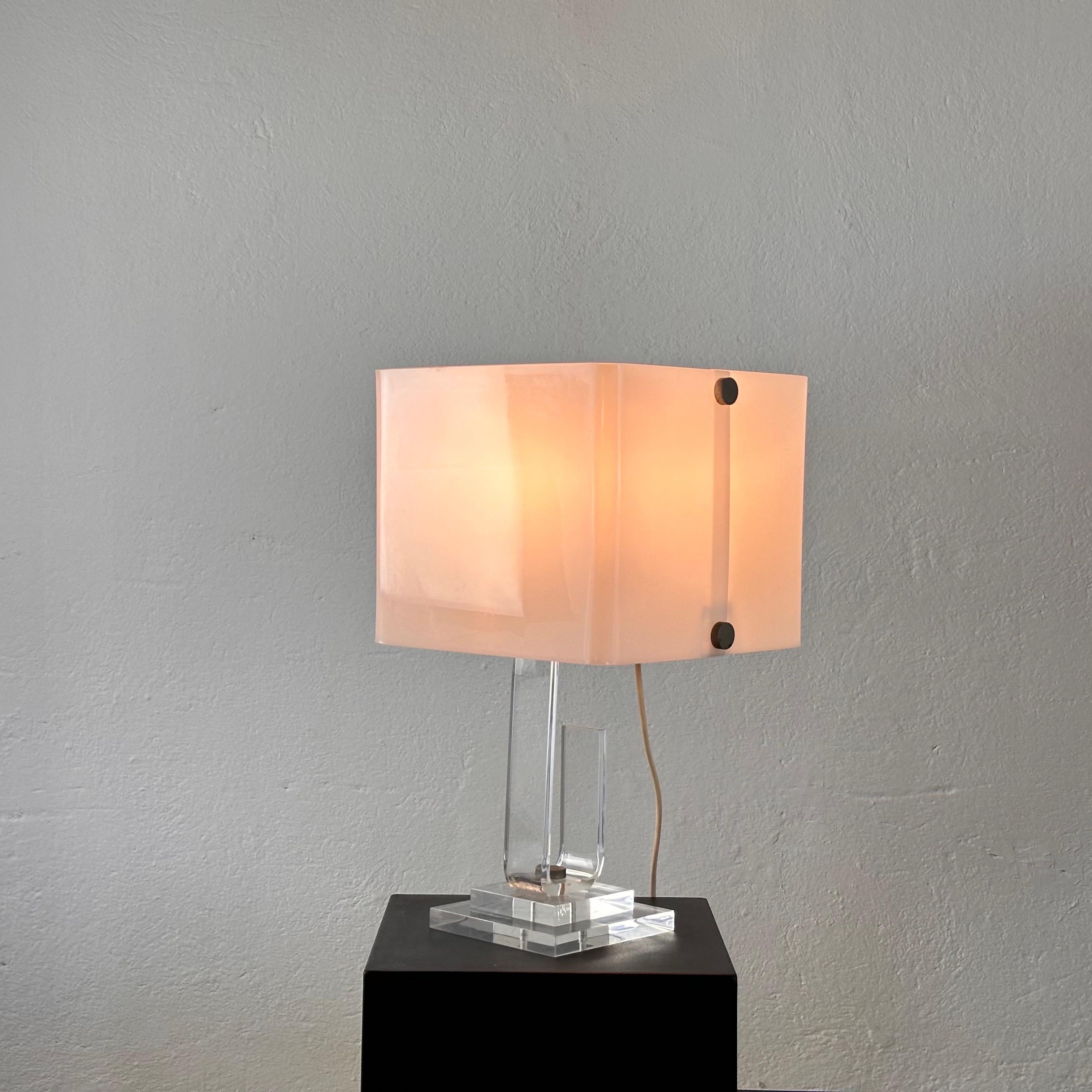 Eleva tu espacio con esta exquisita lámpara de sobremesa de Sandro Petti, un verdadero testimonio de la delicadeza del diseño italiano de los años setenta. Fabricada en plexiglás, esta pieza emana un aura de elegancia atemporal, reflejo de la
