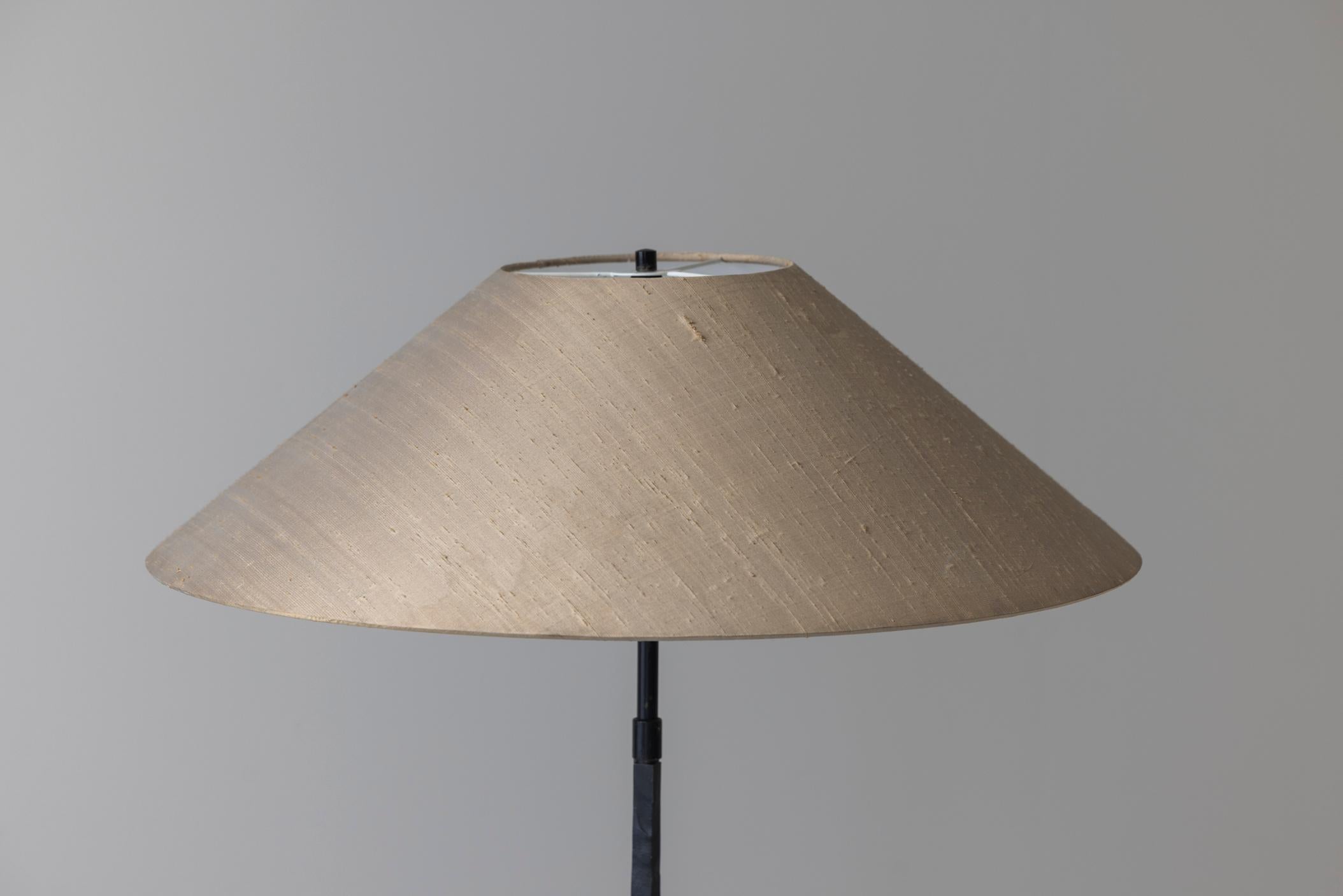 Magnifique lampadaire sculptural des années 1980. Cette lampe est dotée d'une base conique et angulaire en métal lourd, ce qui lui confère une impression de durabilité et de stabilité. La surface de la base semble être subtilement texturée ou finie
