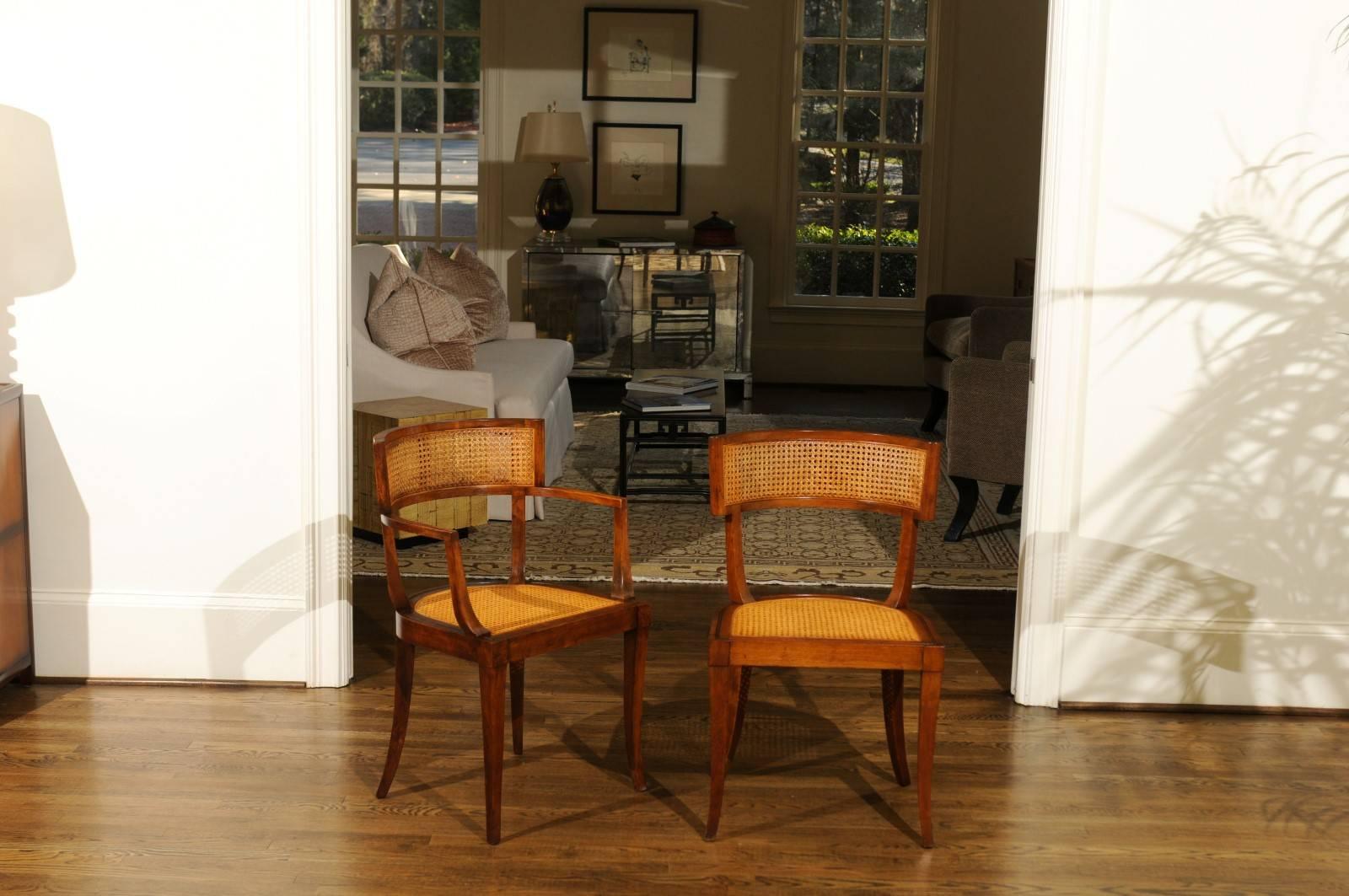 The rarest of the rare: An exceptional, meticulously restored set of twelve (12) cane back Klismos dining chairs by Baker Furniture, circa 1958. This design is routinely attributed to the esteemed Michael Taylor. Expertly crafted solid Cherry