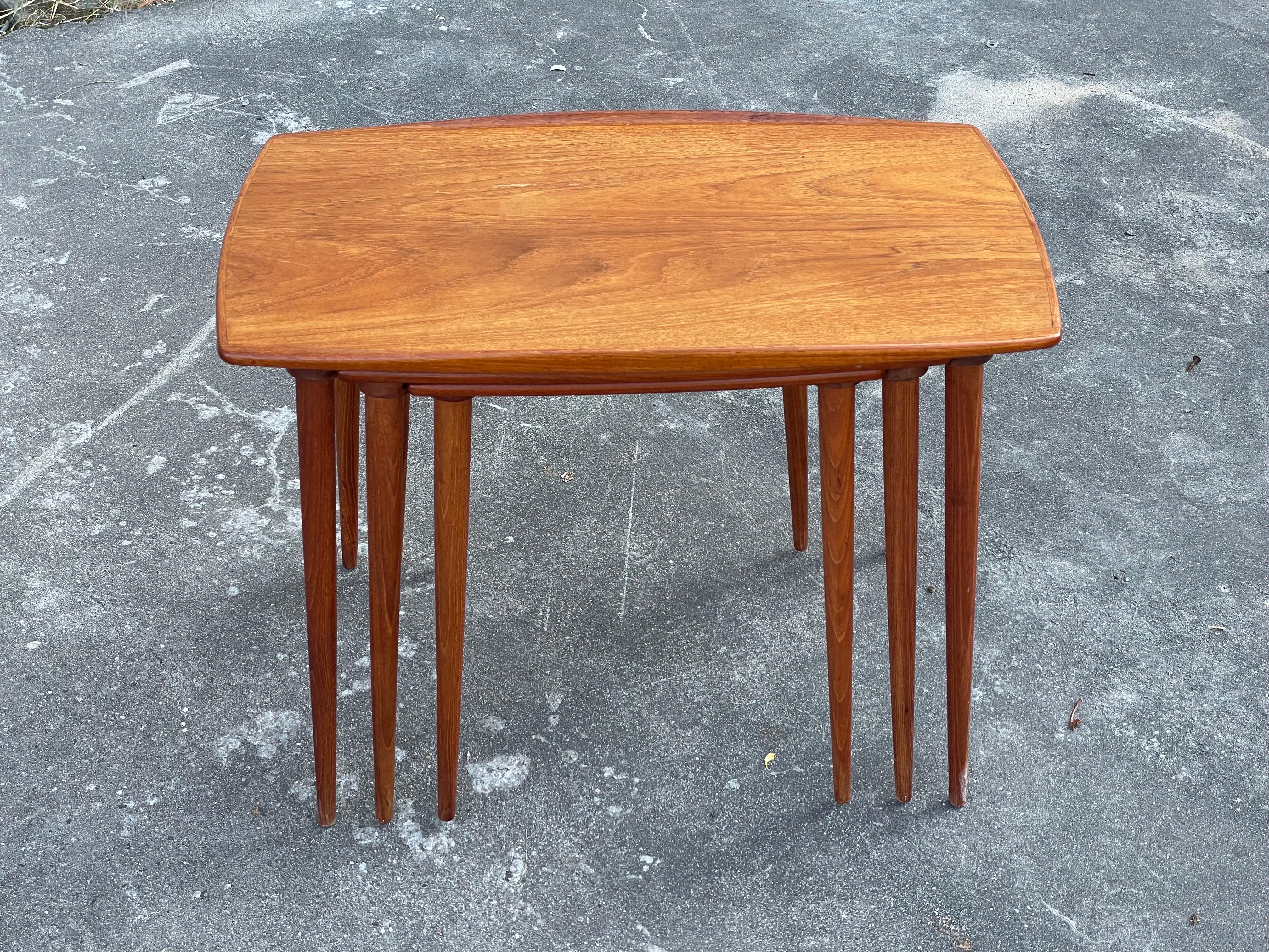 Un magnifique ensemble de tables gigognes danoises en teck des années 1960 avec un superbe bord festonné sur la table supérieure.... Ils sont rarement vus dans cette taille et ont très certainement un nom de créateur qui n'a pas...  n'a encore été