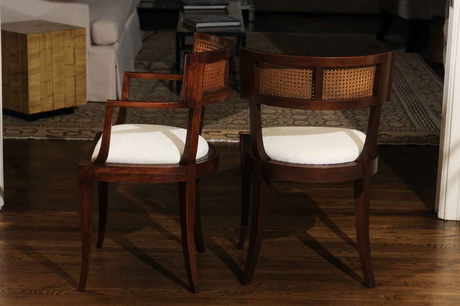 The rarest of the rare: an exceptional, meticulously restored set of eight cane back Klismos dining chairs by Baker Furniture, circa 1958. This design is routinely attributed to the esteemed Michael Taylor. Expertly crafted solid cherry construction