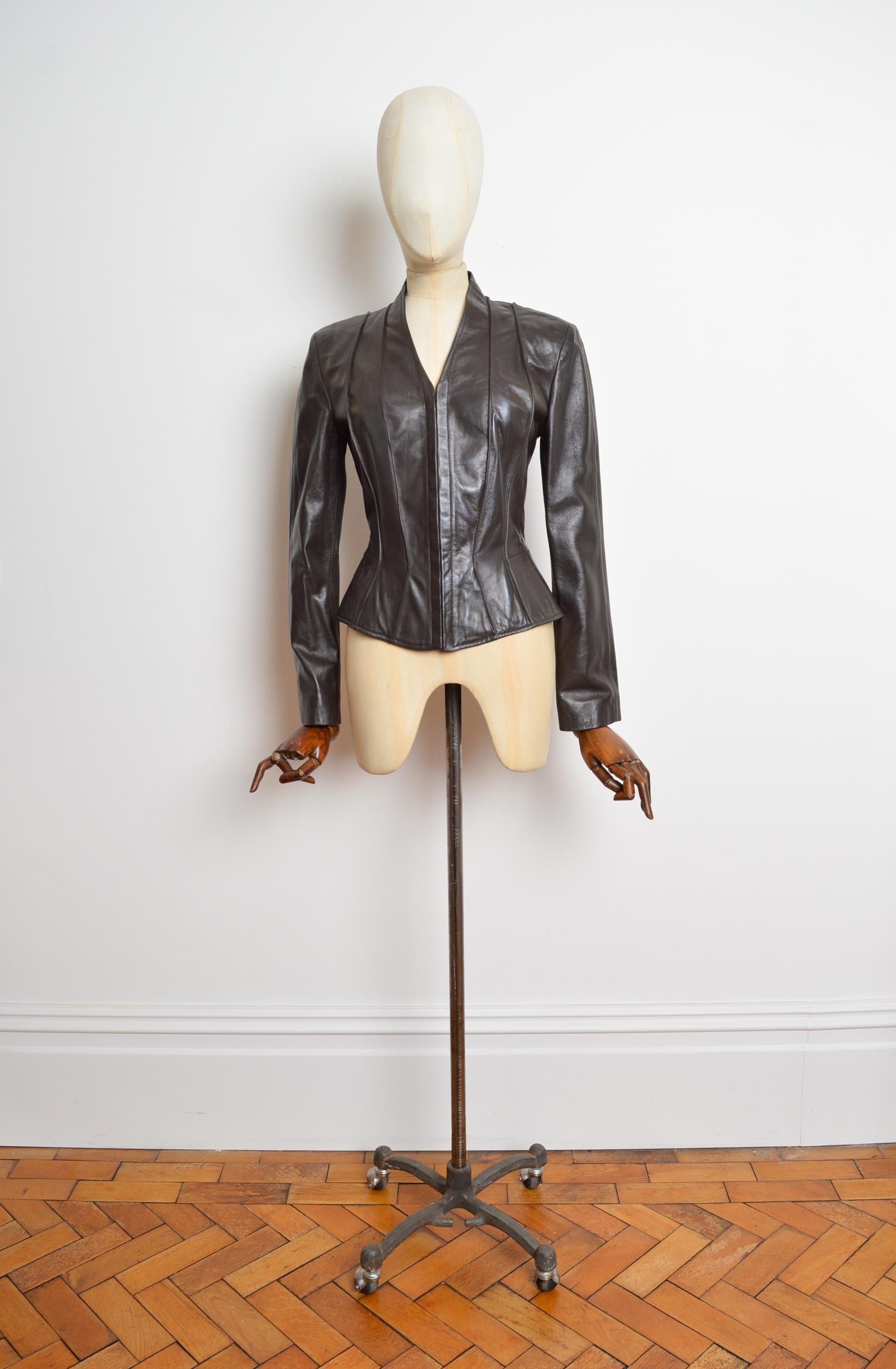 An Exquisite Dark Chocolate Brown leather jacket by THIERRY MUGLER. Circa 2000.
The jacket crafted from lamb skin features a sublime 'wasp-waist' cut with exposed seams down the body and farrier hook fasten closure, just like a Corset. It is
