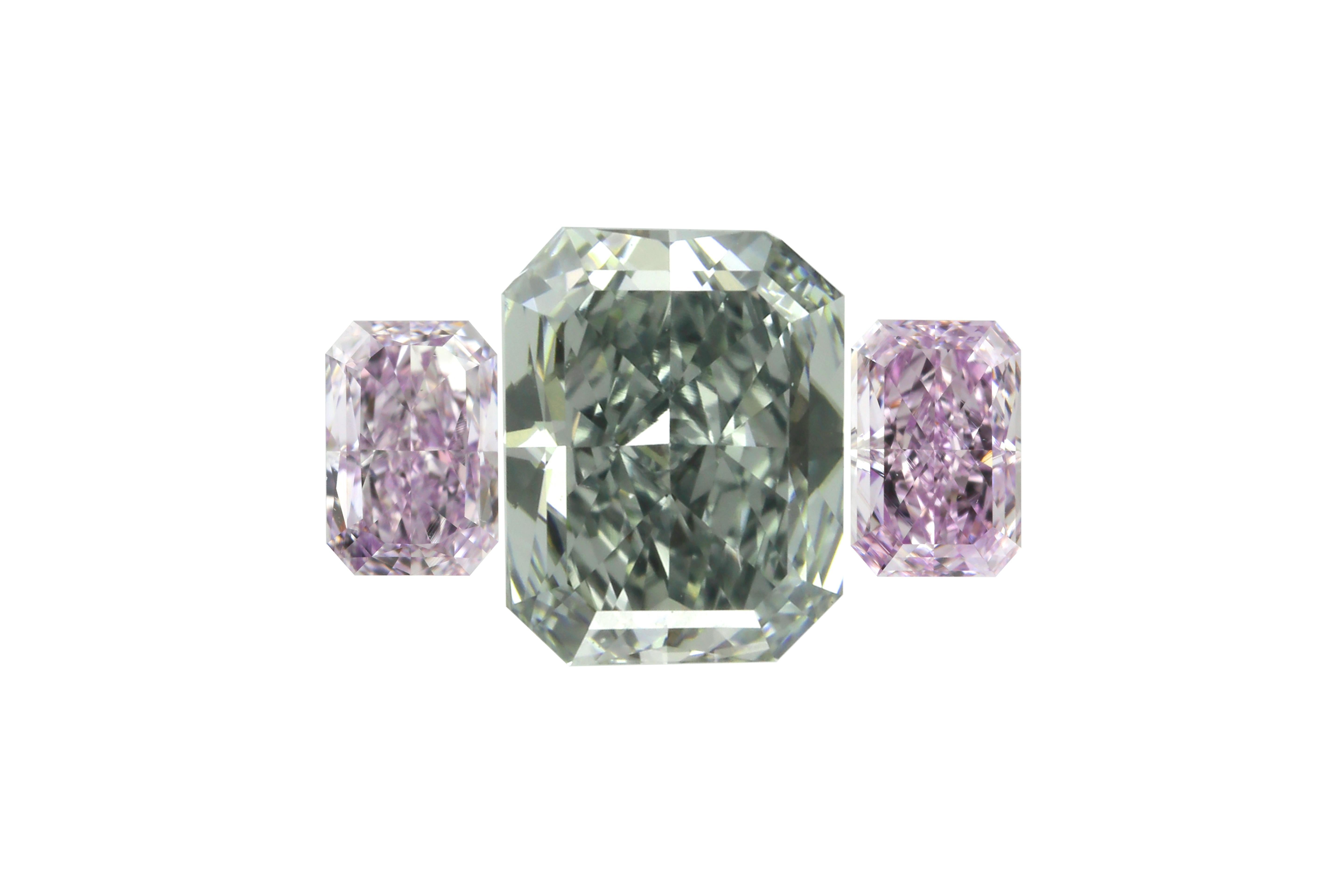 A rare and poetic trio of color, this three-stone diamond set offers an extraordinary opportunity to create a bespoke ring that is both distinctive and deeply romantic. At its center rests a 0.76-carat Fancy Blue-Gray diamond, VS2 clarity and GIA