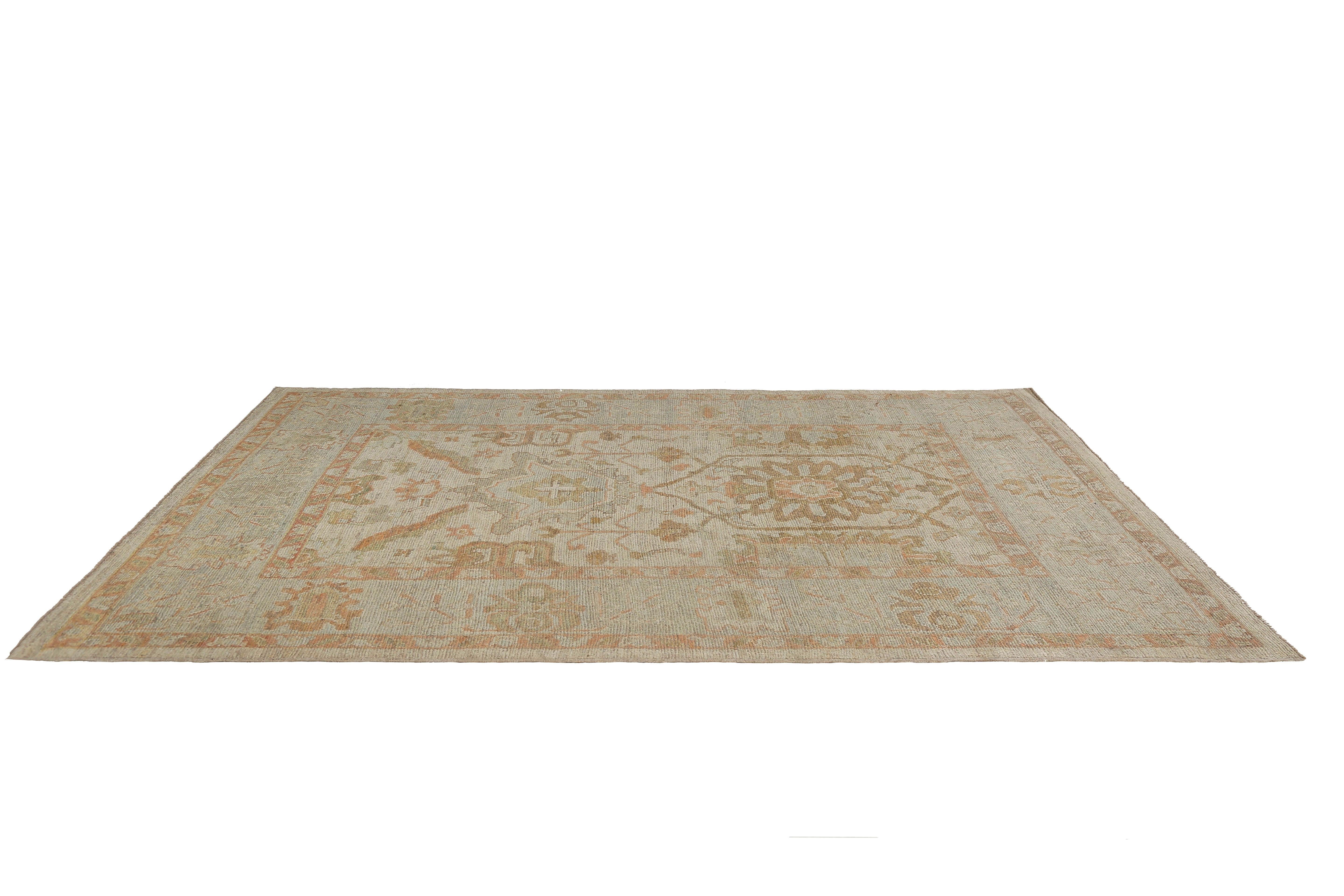 Introducing our stunning handmade Turkish Oushak rug, measuring 6'8'' x 9'9''. This exquisite rug features a beautiful beige background adorned with muted pastel colors including blue, orange, and yellow. Each rug is carefully crafted by skilled