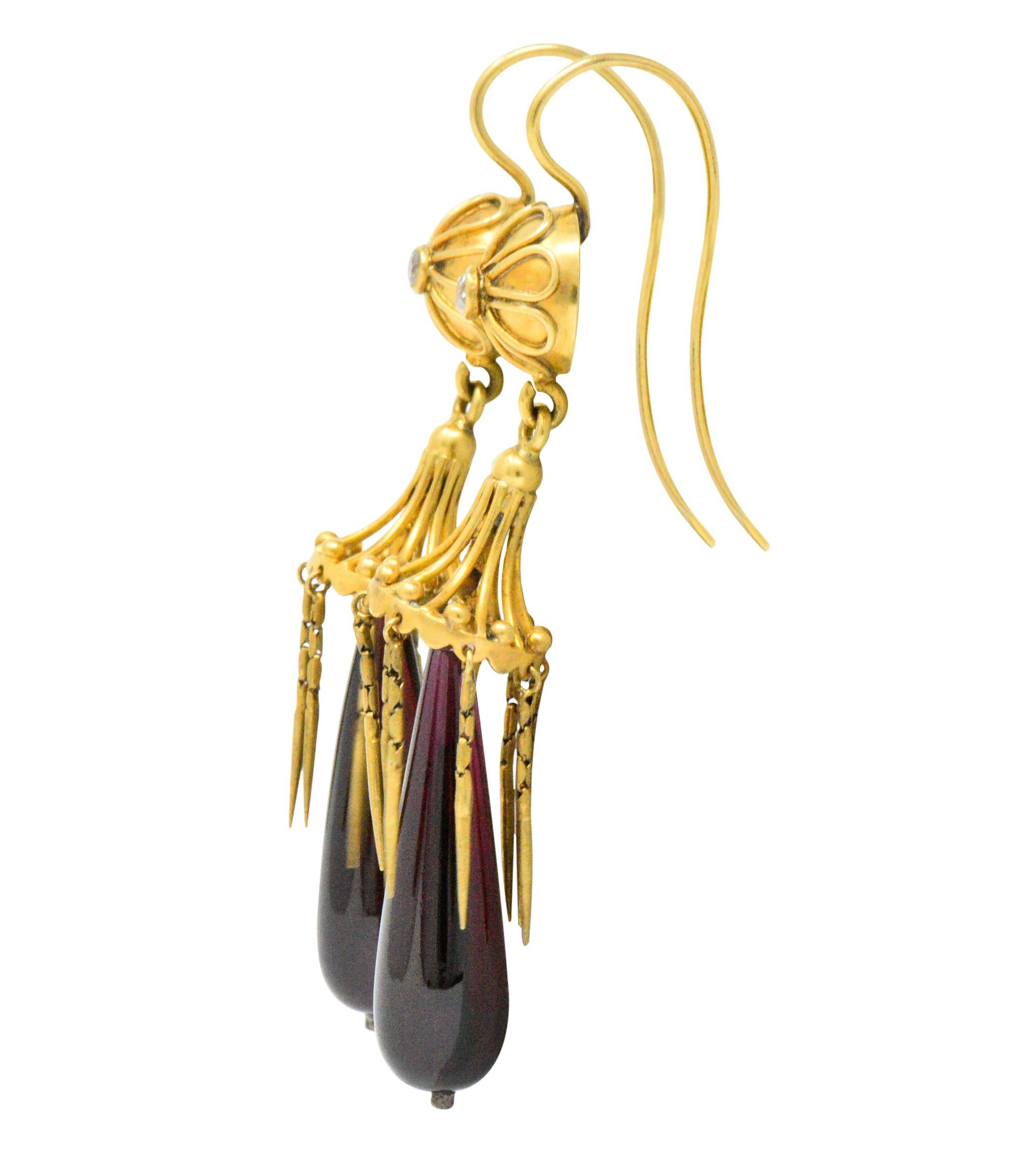 Stunning earrings with polished articulated garnet drops, deep, rich and slightly purplish red

Each surrounded by eight delicate articulated tassels

Suspended from polished gold and gold wire flowers, each centering an old mine cut diamond,