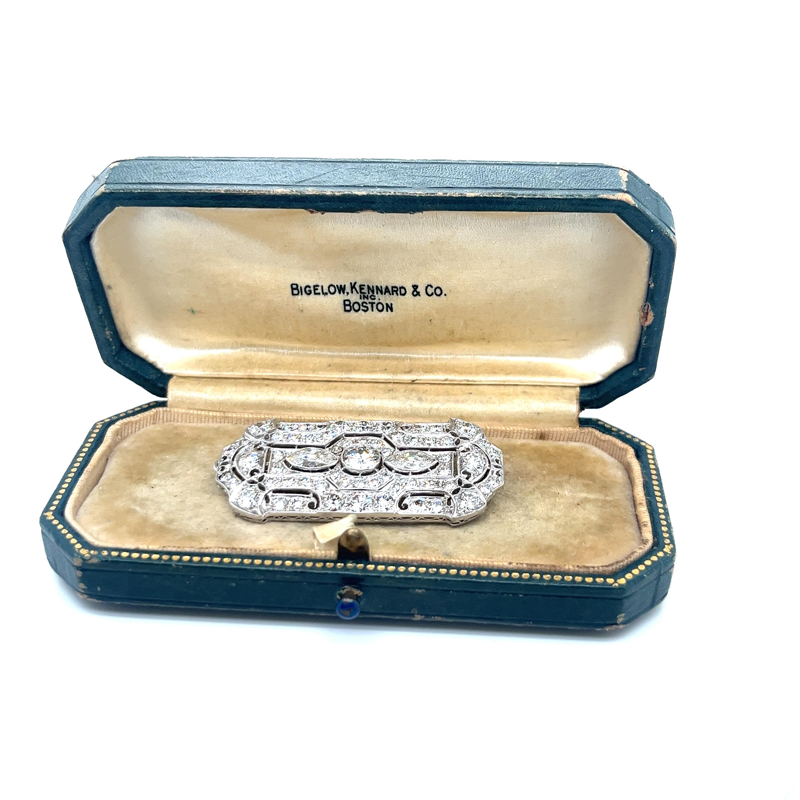 This magnificent Art Deco period brooch exemplifies the sophisticated craftsmanship of the era, masterfully handcrafted in pure platinum with remarkable attention to detail. The piece commands attention with its striking dimensions of 1¾ inches in