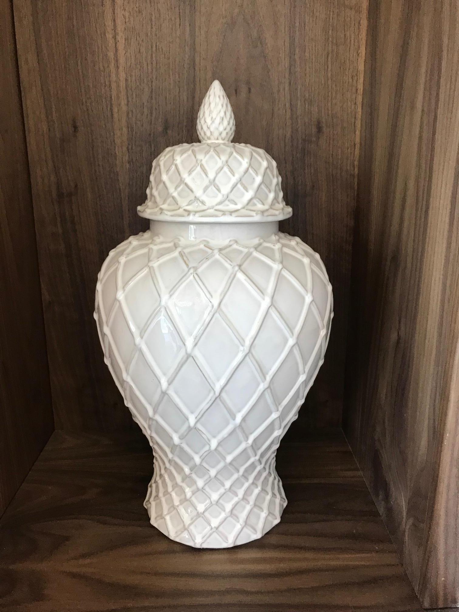 Hollywood Regency large pottery ginger jar with lid has gorgeous urn form with white glaze finish. Features both Chinese and Moorish inspired designs with lattice work throughout. Has tapered base and the lid features a stylized acorn finial or
