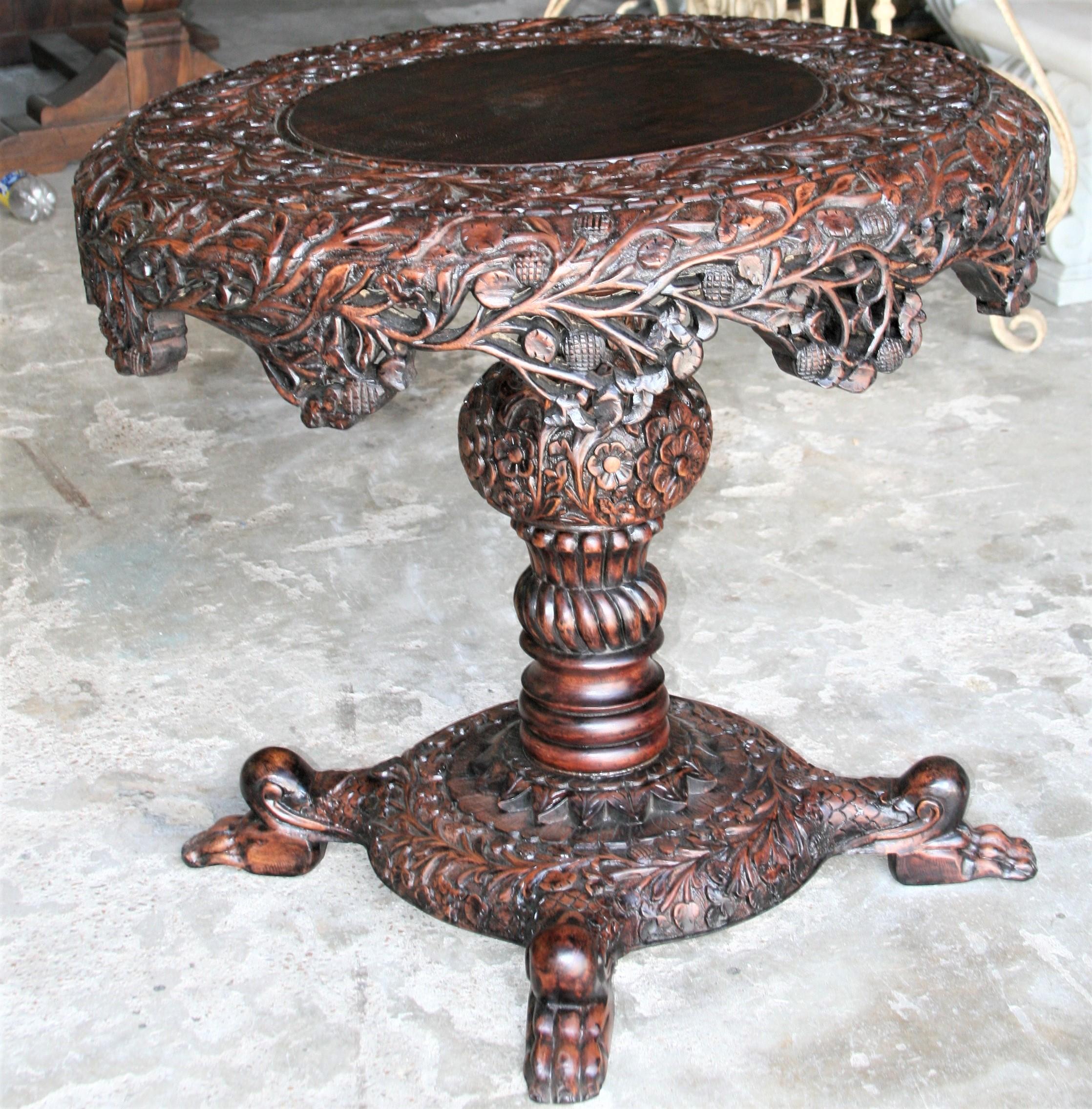The round top edges with apron are pierce carved. It has carved round columnar support with carved square plinth and paw feet. It is an extraordinary table with precise detailed carving. Seller guarantees the quality and material. Will make an