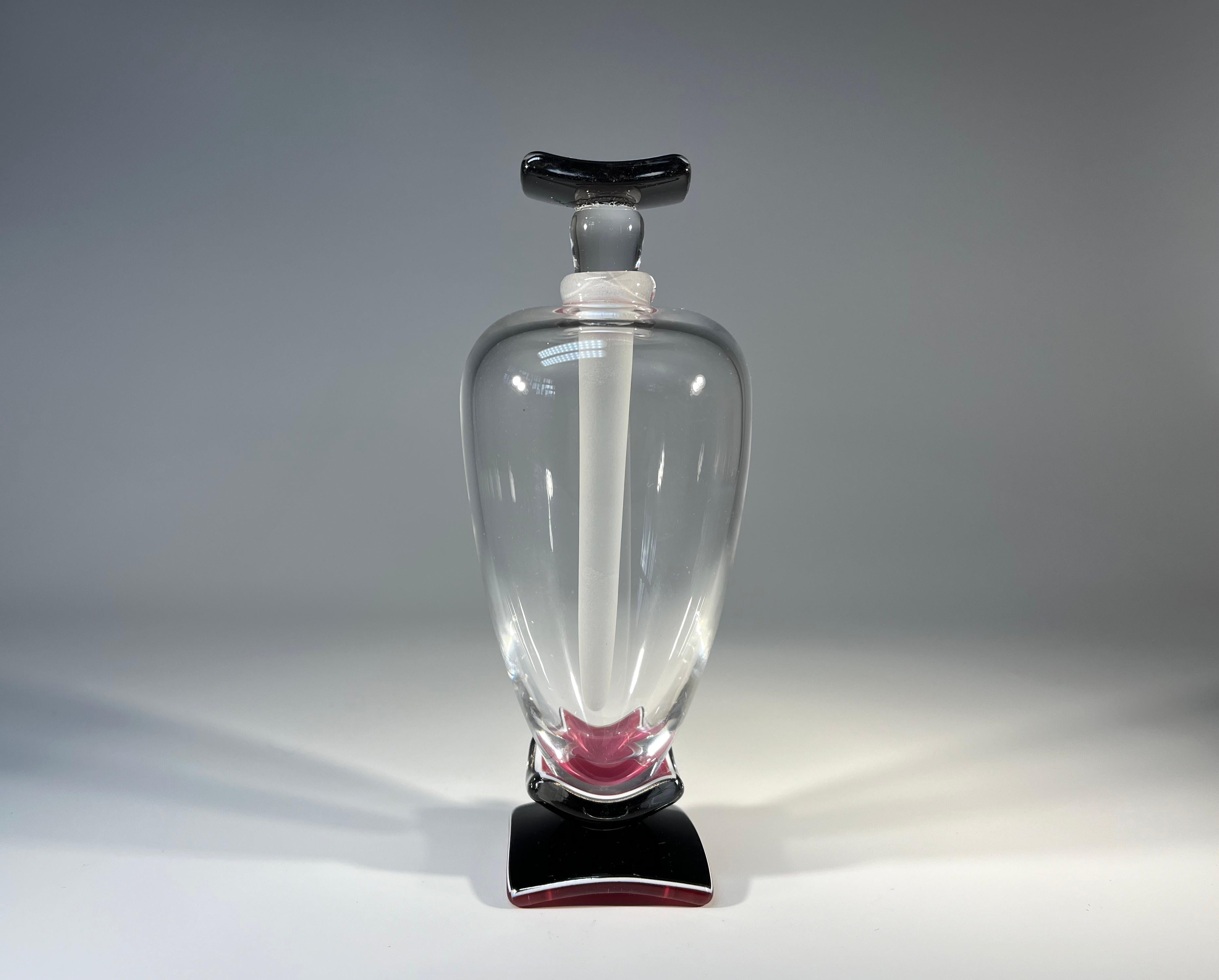 An elegantly tall perfume bottle of clear, deep rose pink and black crystal
Especial elongated frosted crystal stopper
Created by superbly talented glass artist Anthony Wassell, England
Signature etched to base
Circa 1990-2003
Height with stopper 6