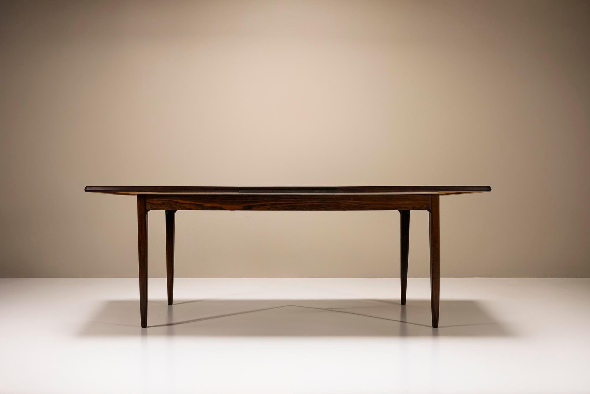 Extendable boat-shaped dining table in palissander wood.

This elegant dining room table is a refined example of Danish craftsmanship and both the design and construction have stood the test of time. The table can be extended by simply extending