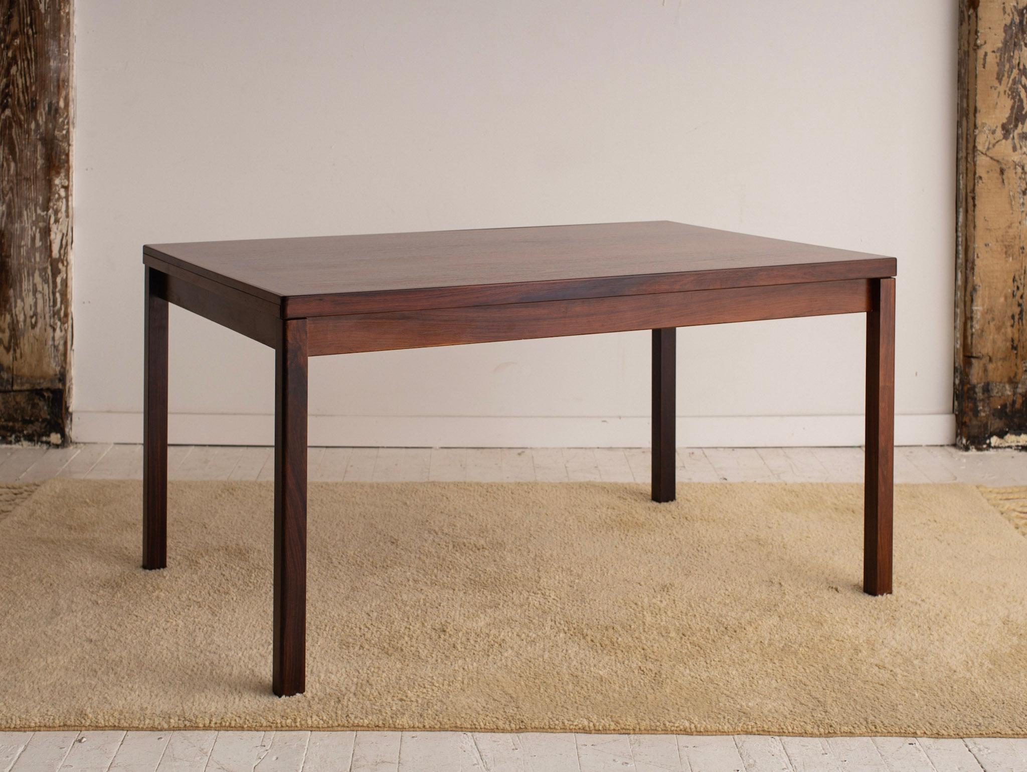 Mid-Century Modern Danish dining table in rosewood. Beautiful rich wood grain. Two extendable leaves tuck away under tabletop. Table width extends to 95.“