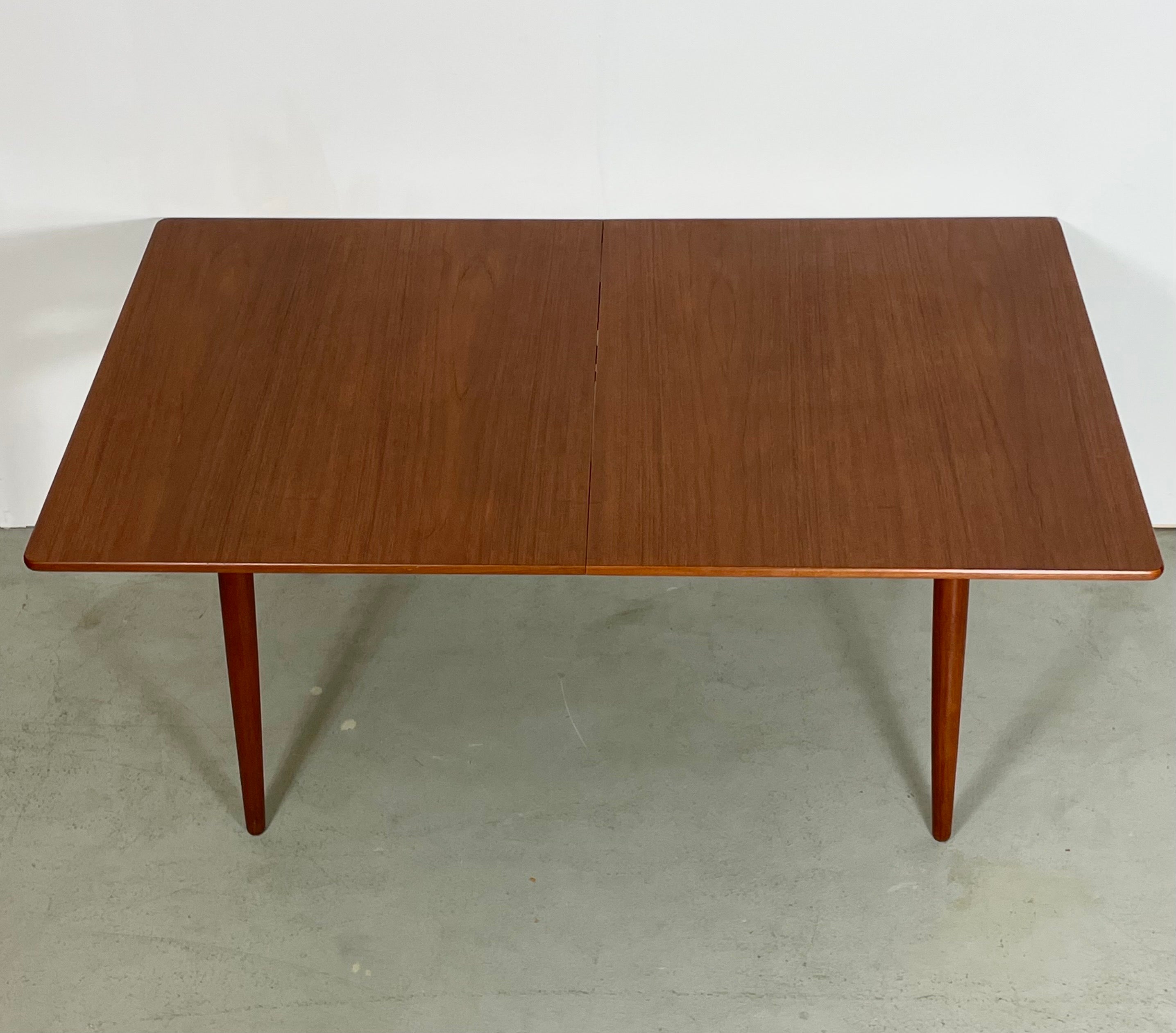 Il s'agit d'une belle et très rare grande édition du modèle AT 310. Une table à manger conçue par Hans J. Wegner, produite par Andreas Tuck au Danemark. Équipé de 2 feuilles d'extension séparées de 40 cm chacune. Pieds et plateau de table en teck.