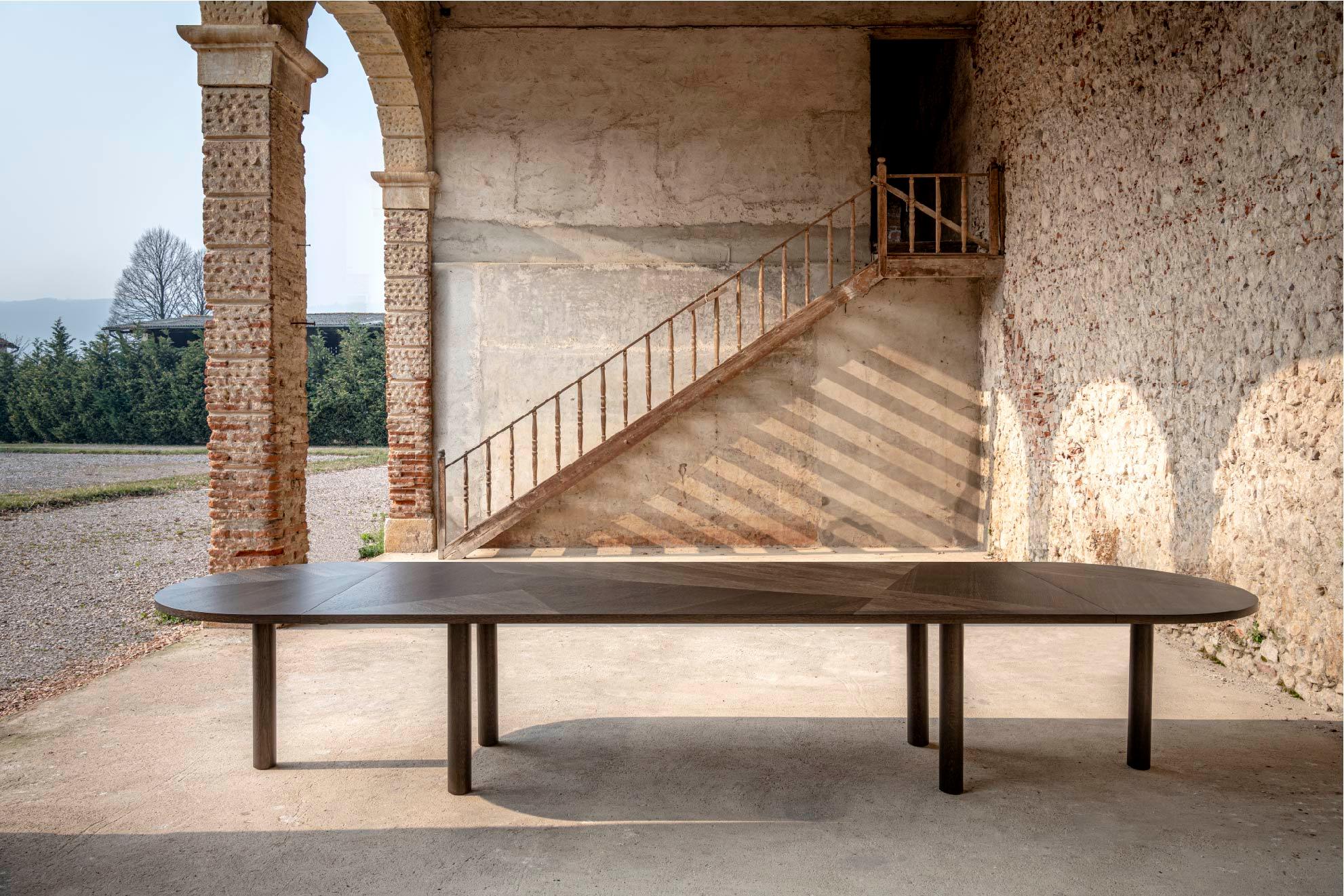 When the client approached me he asked me to design a table that will accommodate everyone around it. Hence the name La Famiglia.

The table is made from European Oak, its basic size is 400cm x 120cm, only 3.2cm thick. 
The extensions 60cm and